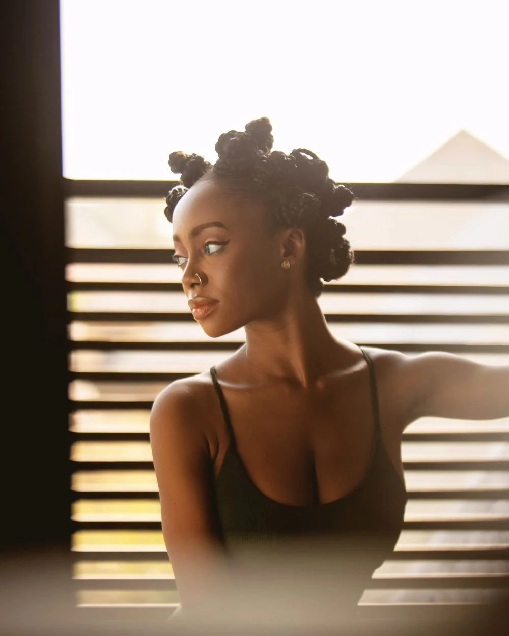 Woman looking away in contemplation, representing the inner self-doubt addressed in imposter syndrome therapy