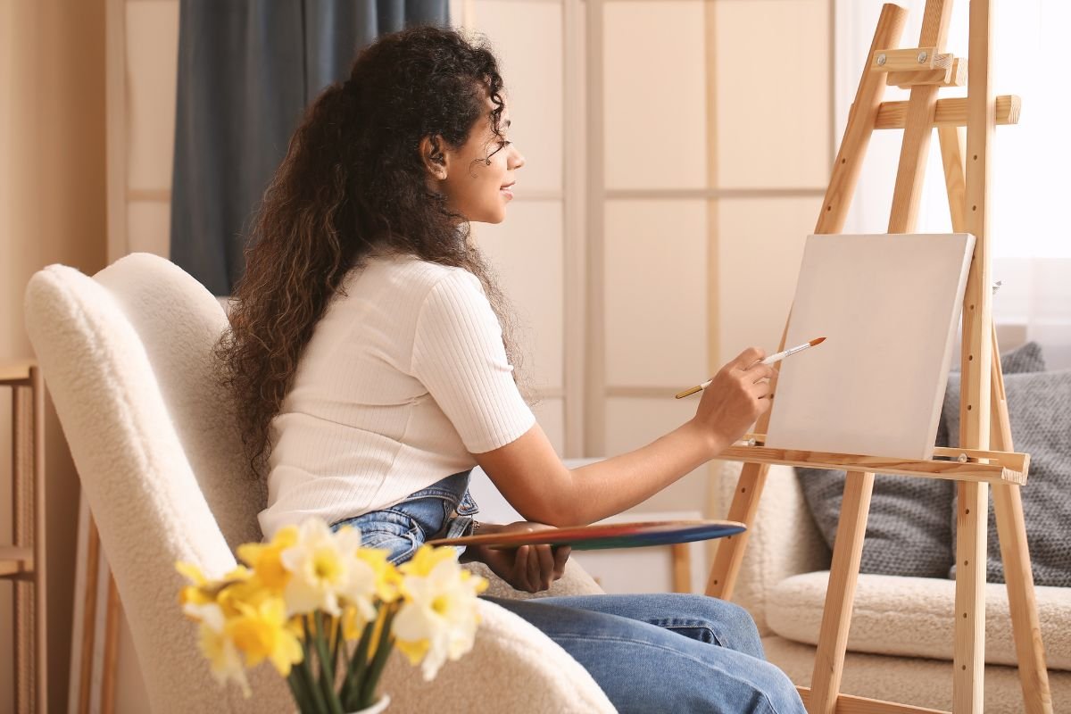 Woman painting quietly at home, representing the calm first step of booking a therapy consultation