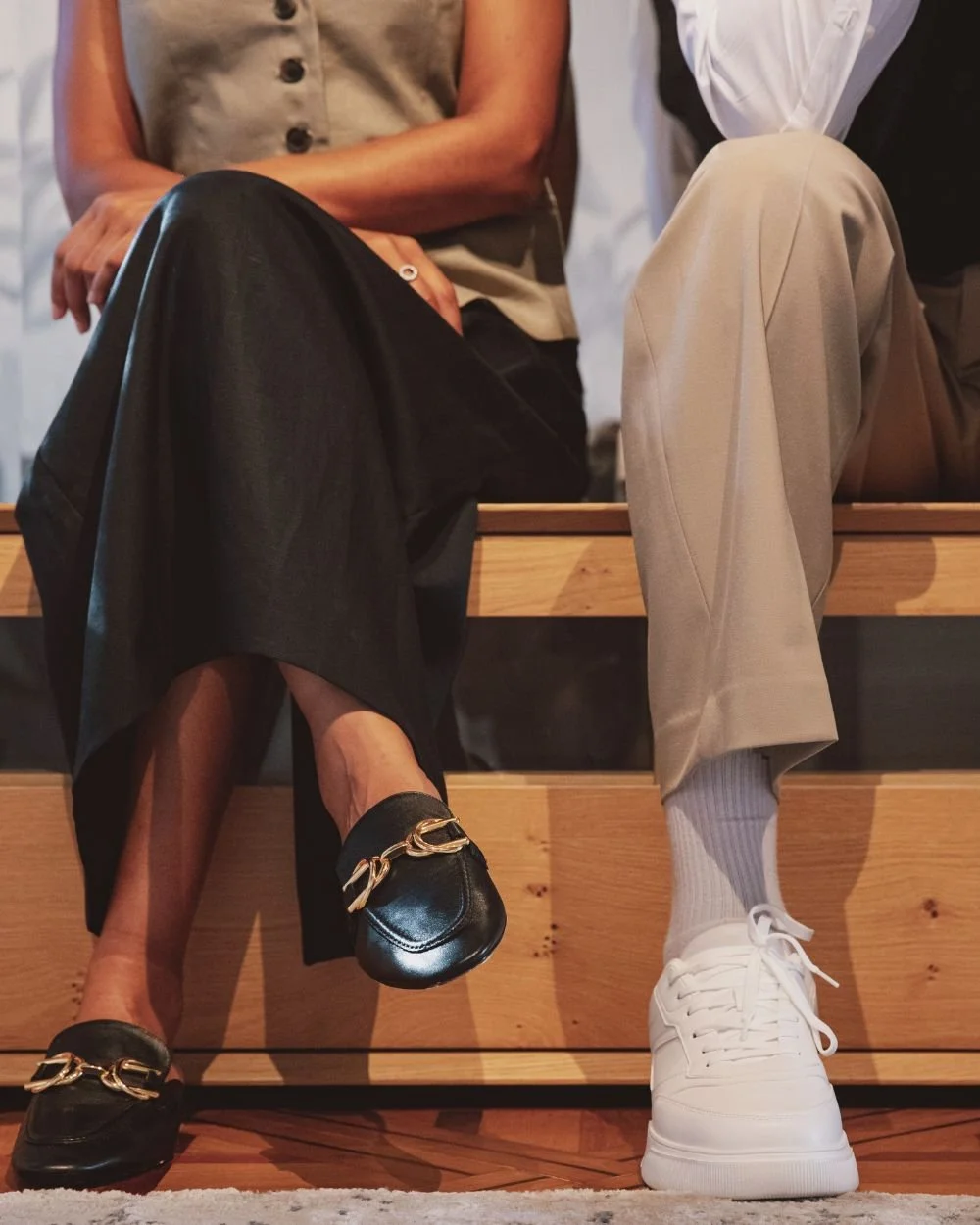 Two women sitting together, polished and composed, representing the gap between looking capable and feeling it