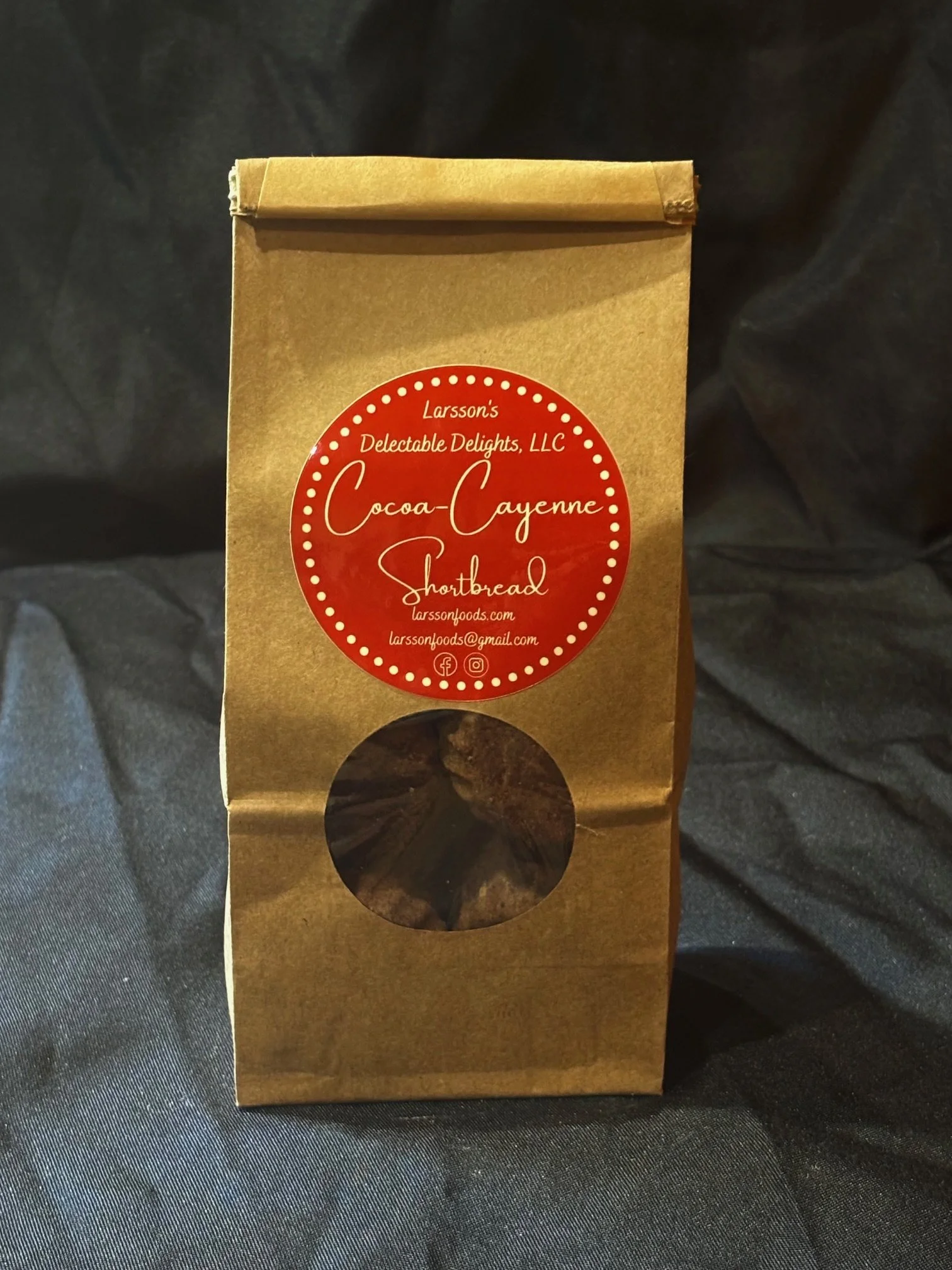 A bag of mini Cocoa-Cayenne Shortbread set in front of a black background