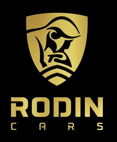 Logo of Rodin Cars featuring a stylized gold face with a beard and a shield shape, with the text 'RODIN' and 'CARS' below.