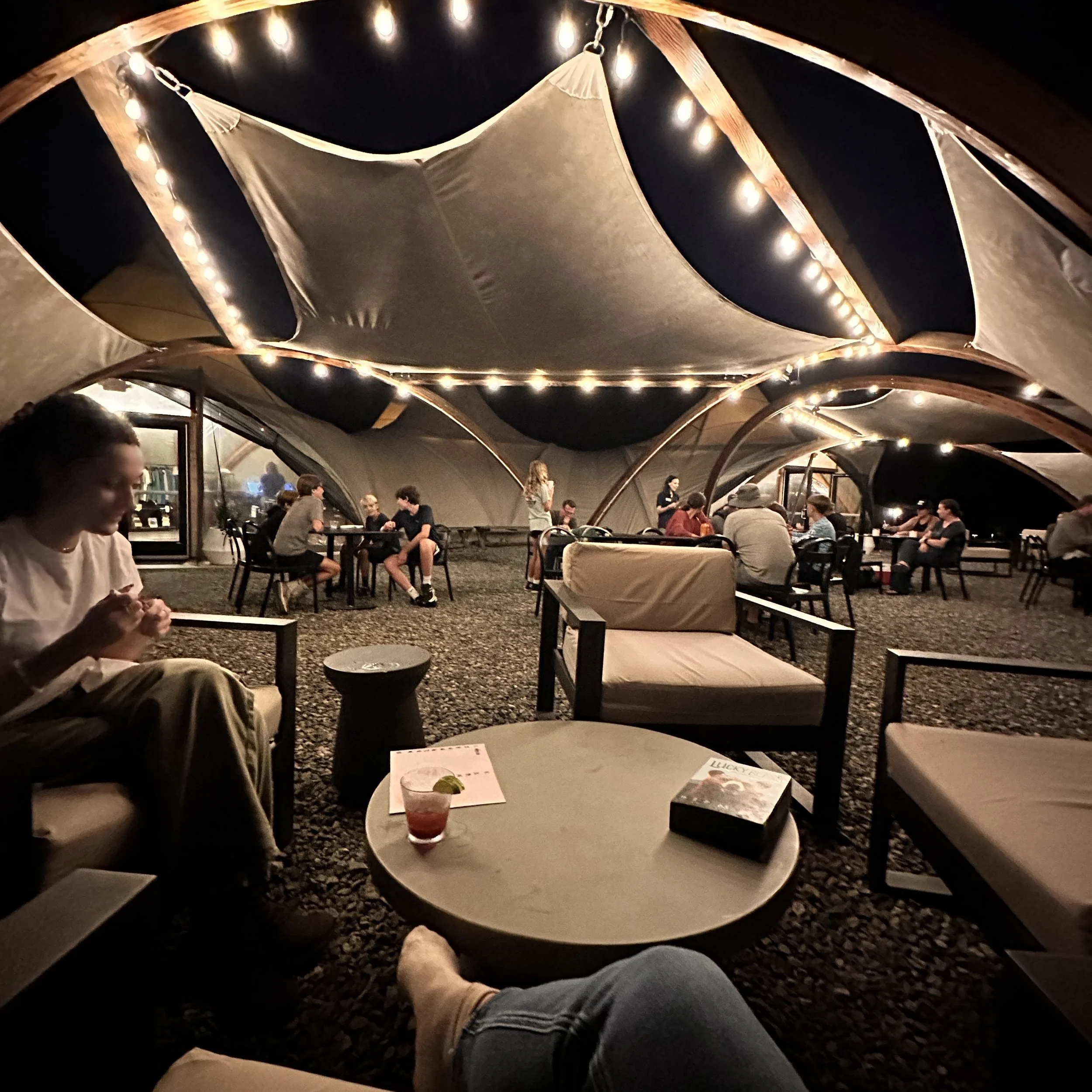Main tent lounge with string lights at Under Canvas Great Smoky Mountains
