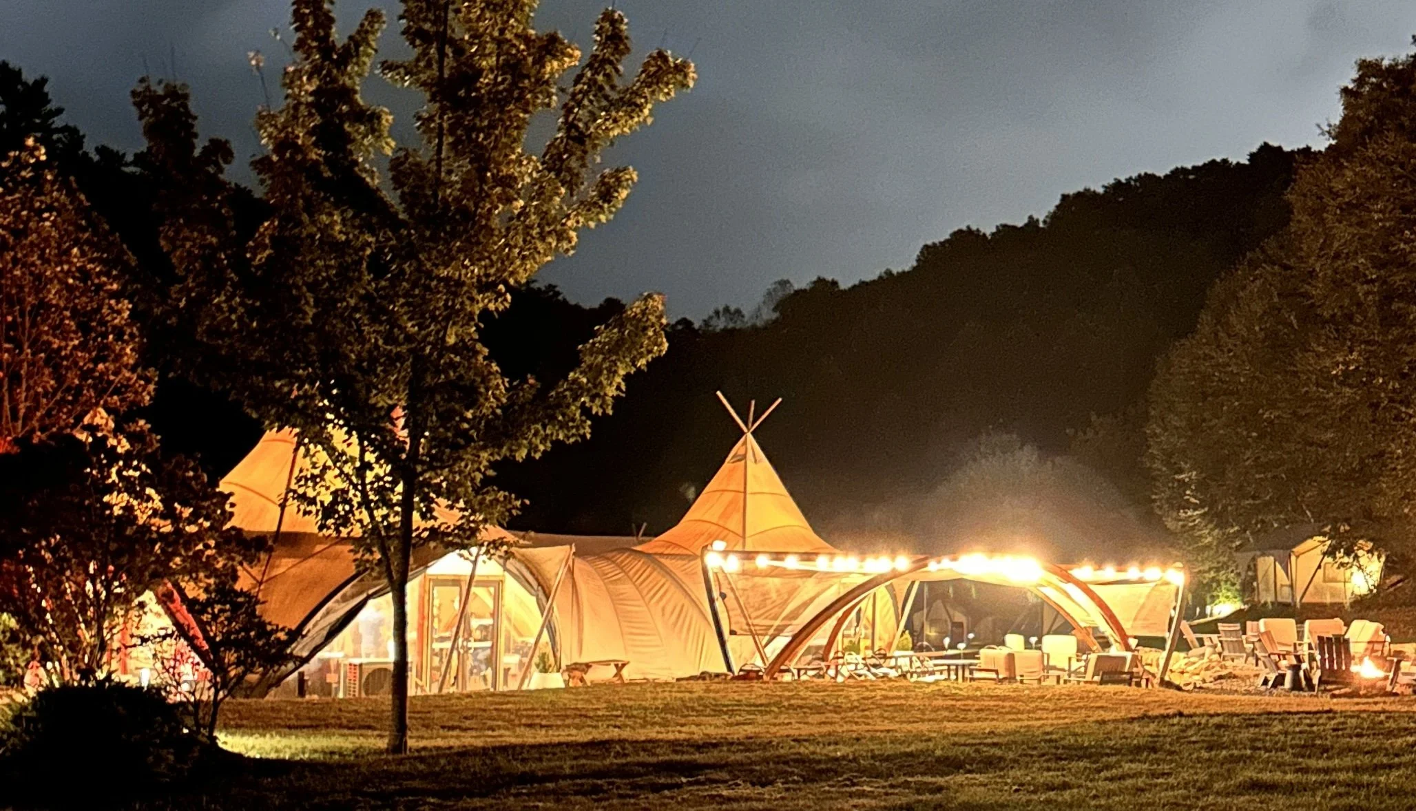 Under Canvas Great Smoky Mountains camp lit up at night with string lights