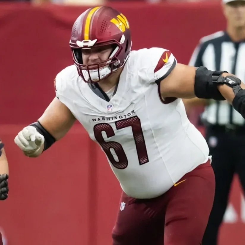 Kansas City Chiefs football player in a red uniform crouching on the field during a game.