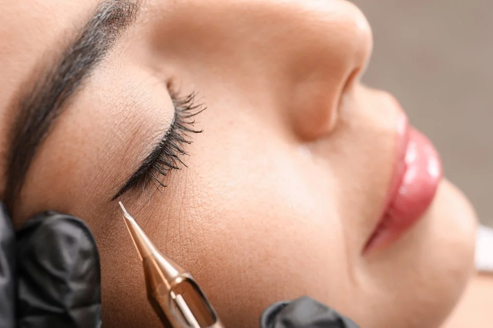 Close-up of a permanent eyeliner procedure in Minnetonka, MN. Showing a technician applying precise pigment to enhance the lash line for a long-lasting defined look.