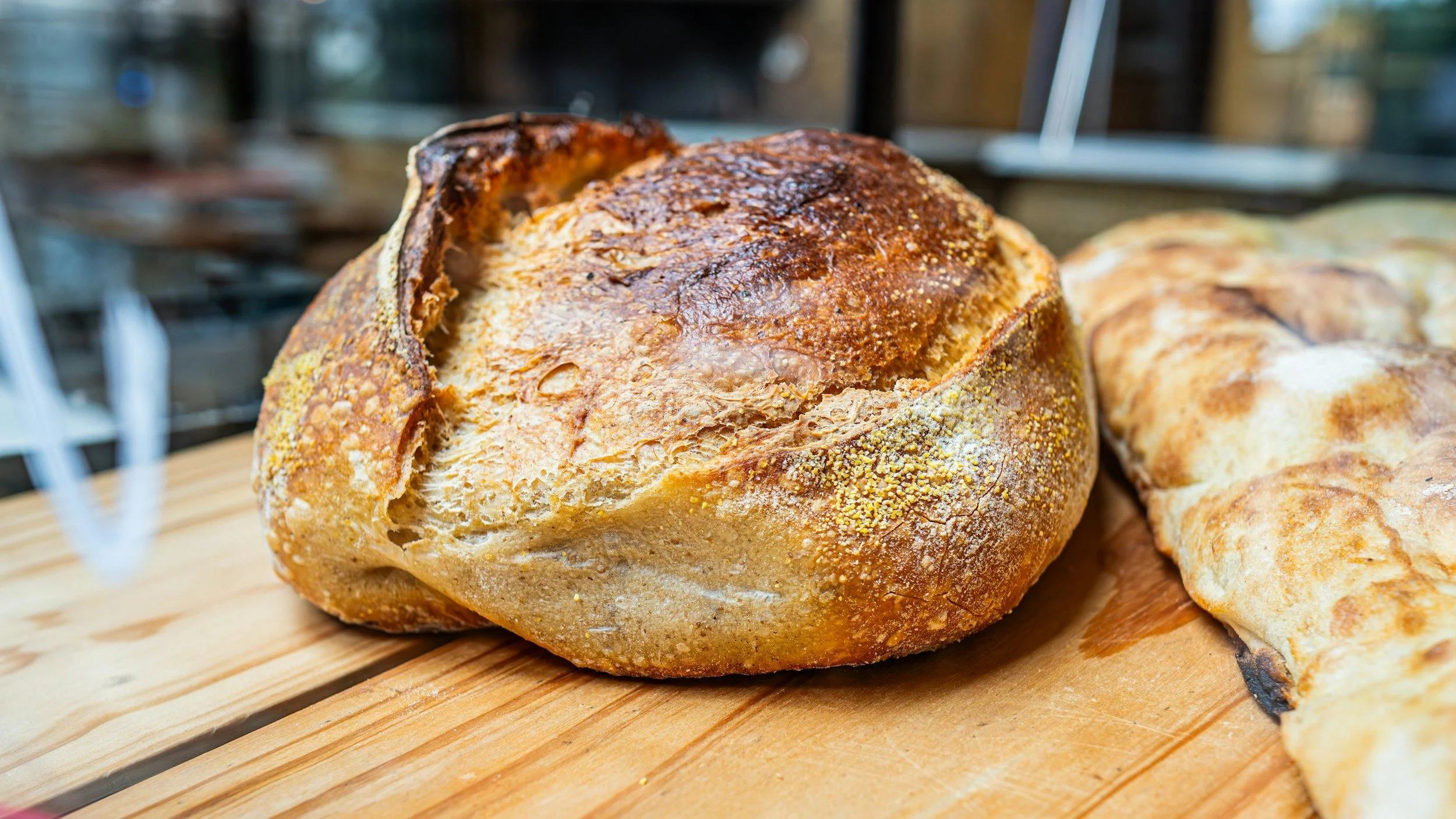 Freshly baked sourdough bread loaf on a wooden table.
