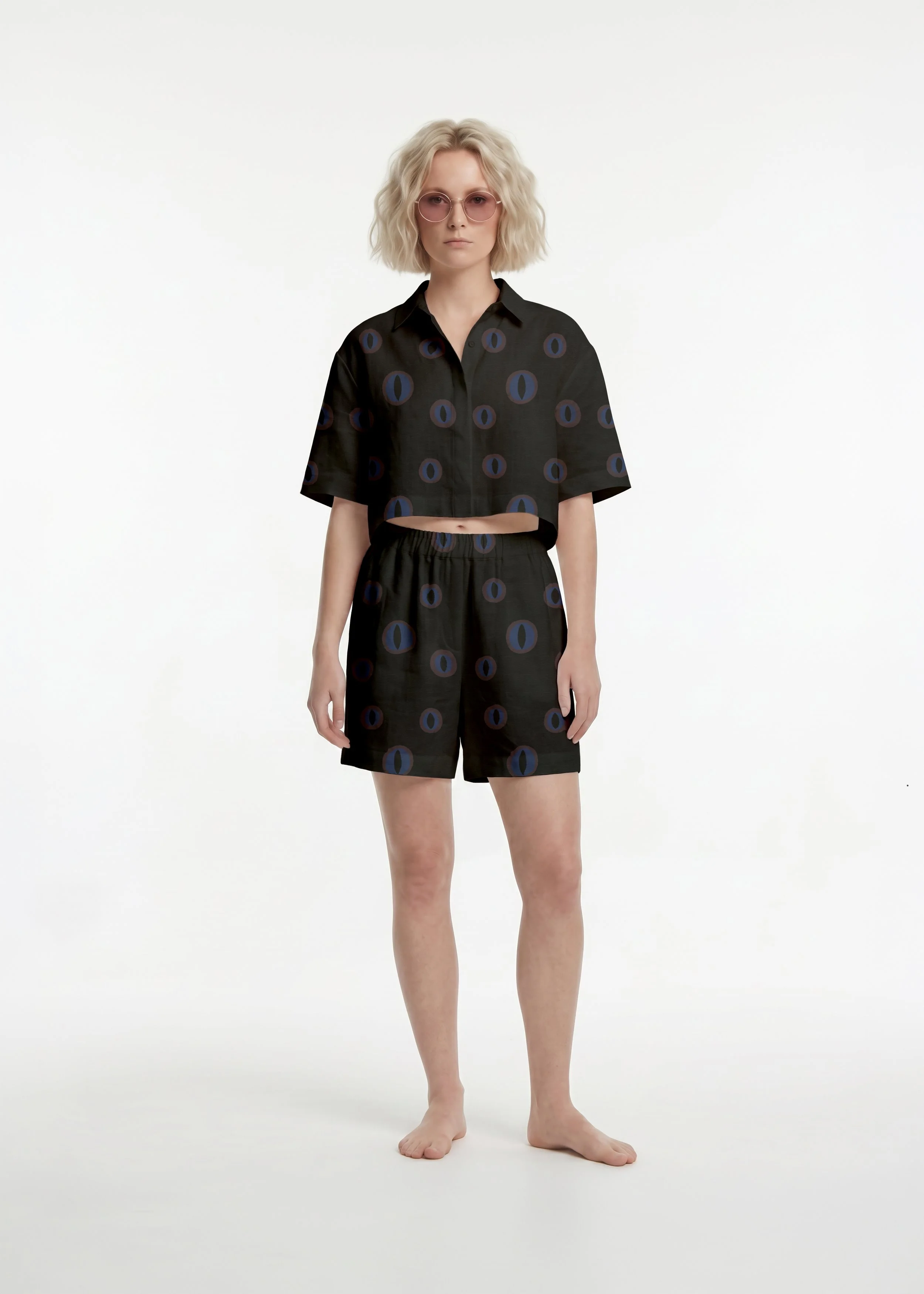 Full-body shot of a woman wearing a dark patterned shorts and shirt set on a white studio background