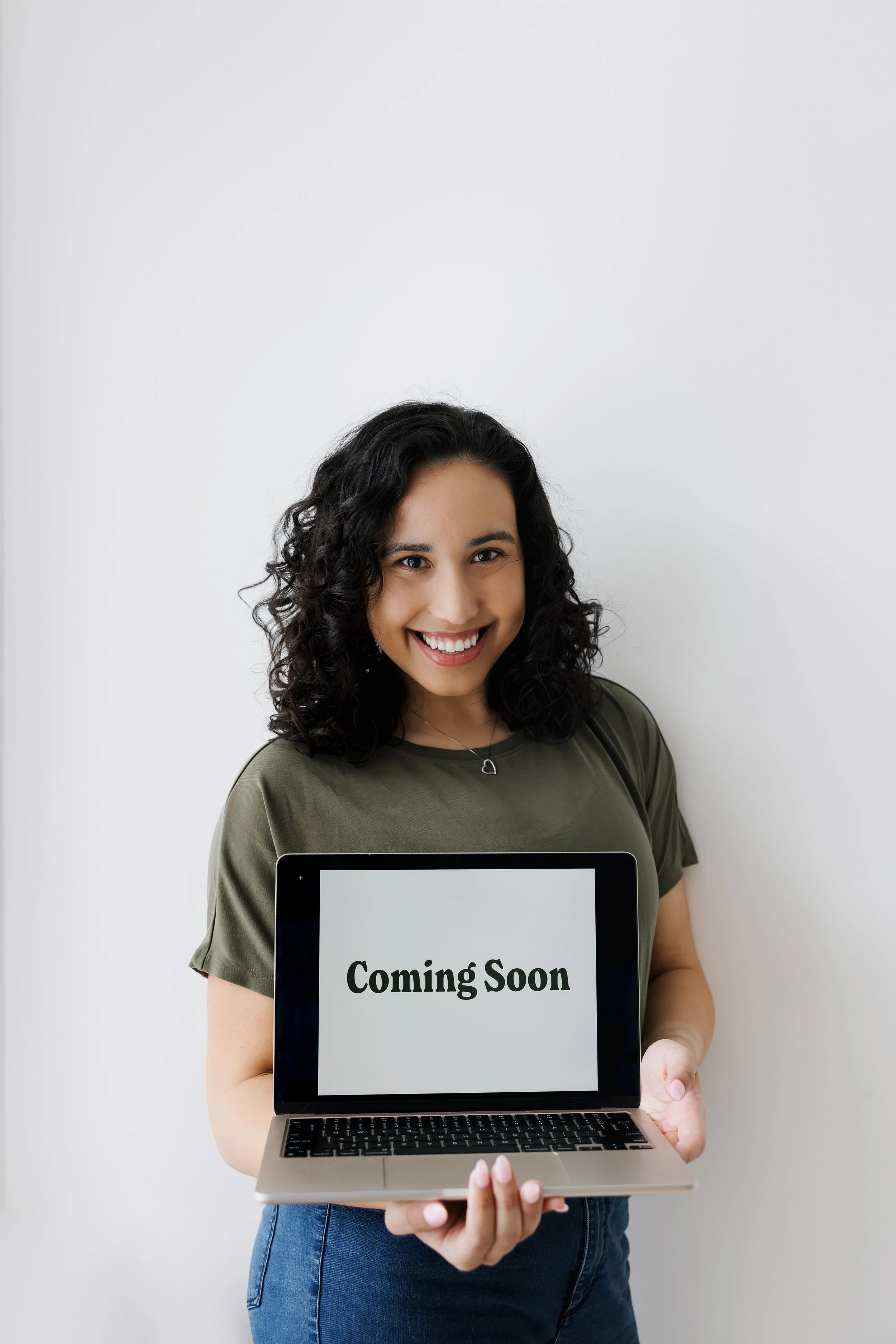 Sierra Johnson holding macbook on the screen saying coming soon