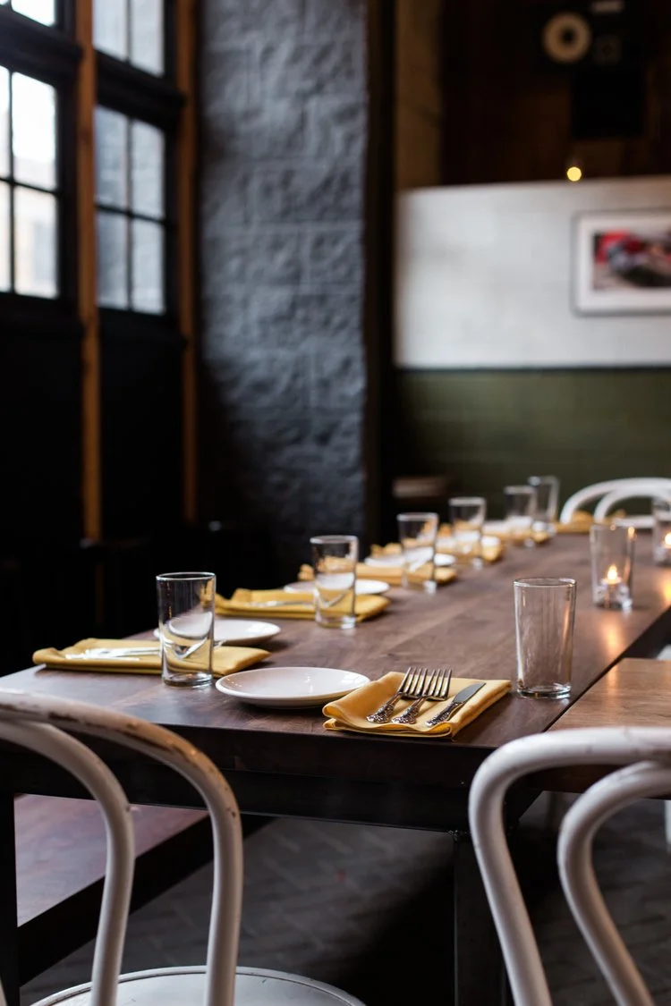 A dining room table inside the OSB is set to host a dozen people in a candlelit space.