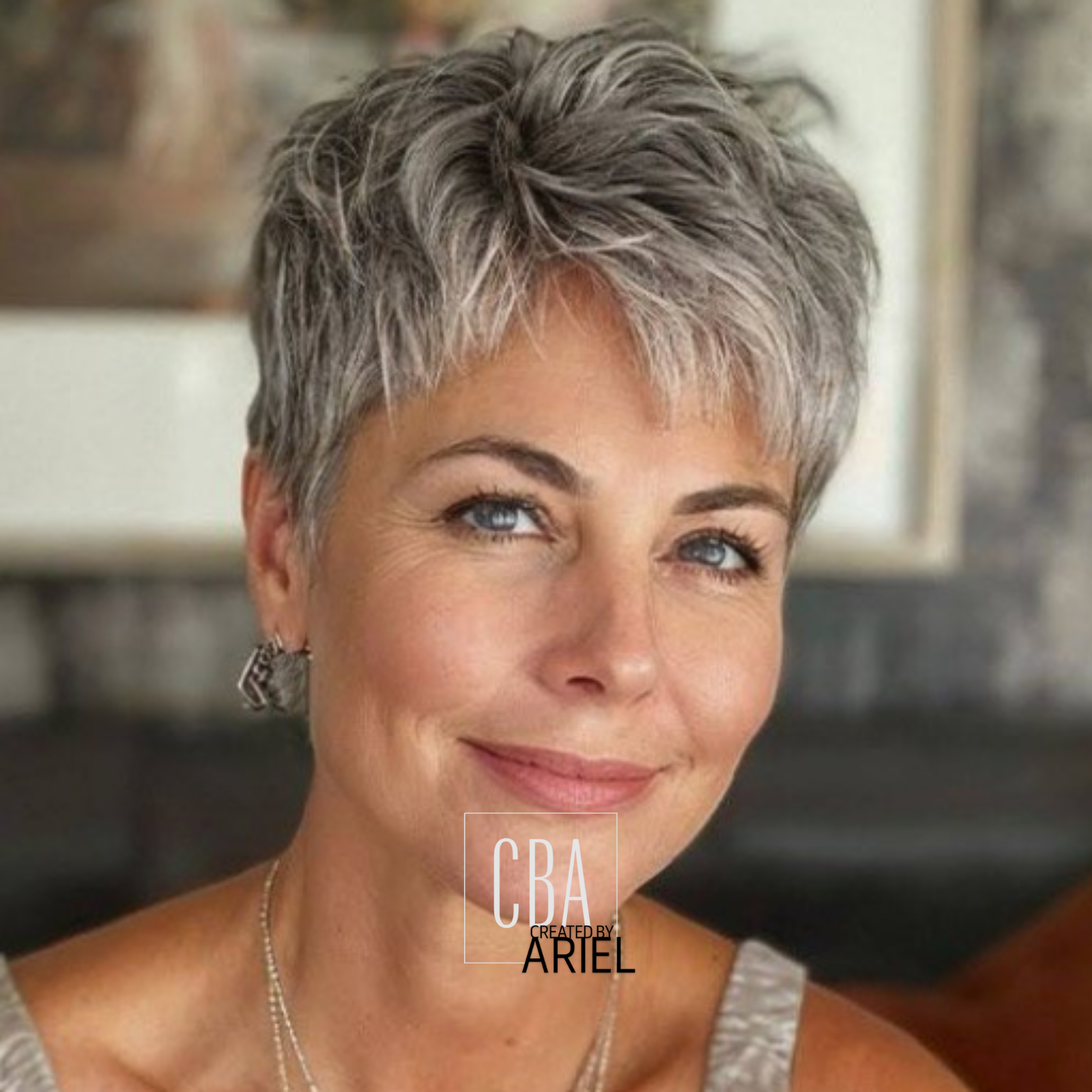 Close-up portrait of a middle-aged woman with short, gray hair, blue eyes, and a friendly smile.
