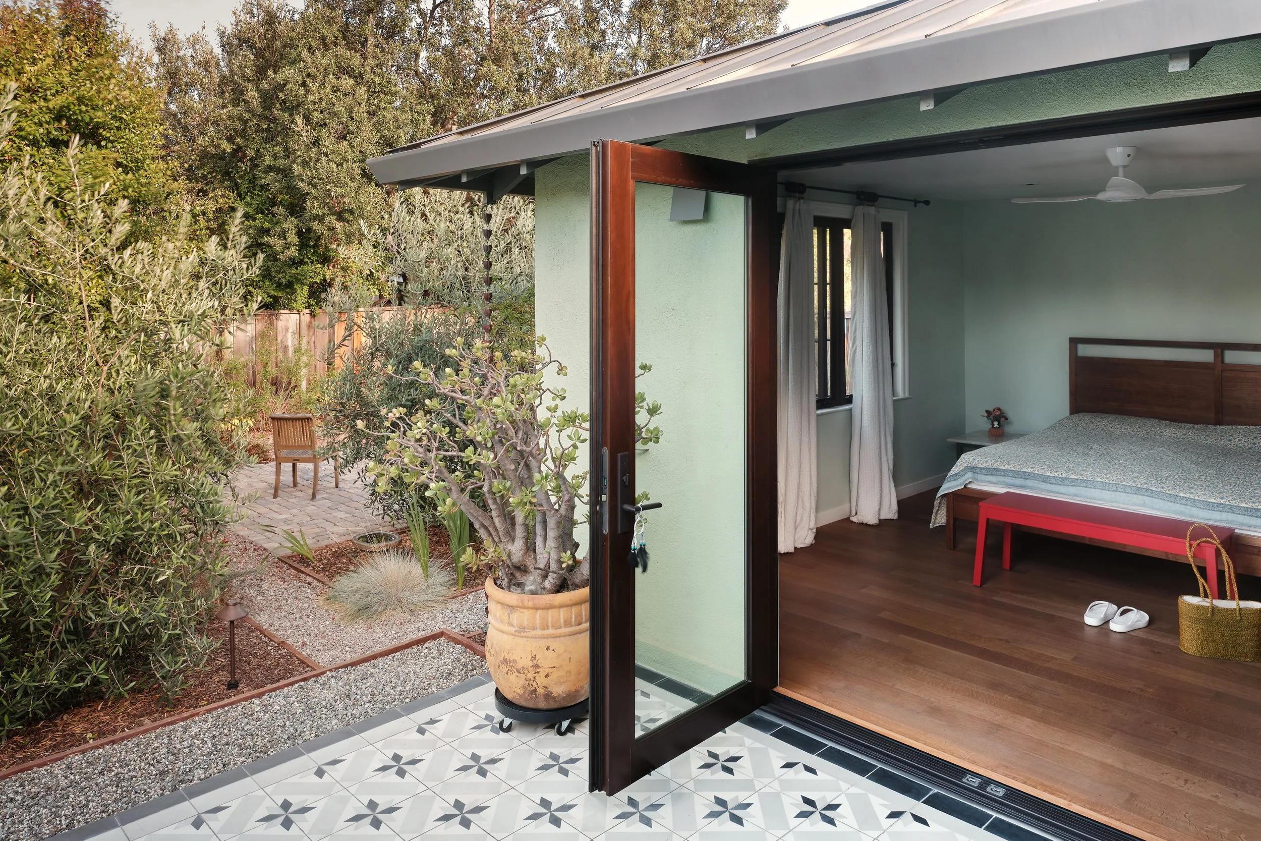 Primary bedroom with French doors opening on to terrace and garden