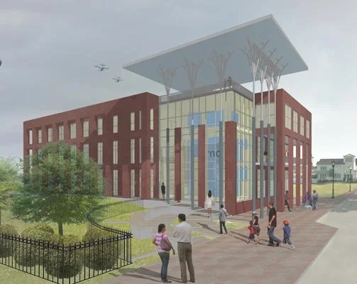 A rendered modern 3 story brick building with a large glass entrance, red brick walls, and a distinctive overhanging roof. People are walking and gathered outside on a paved area with some greenery nearby.