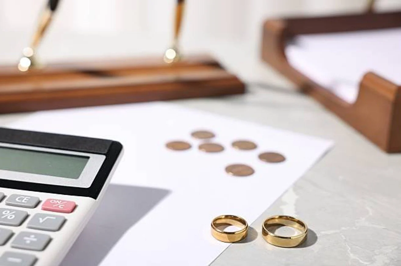 wedding rings on desk with calculator