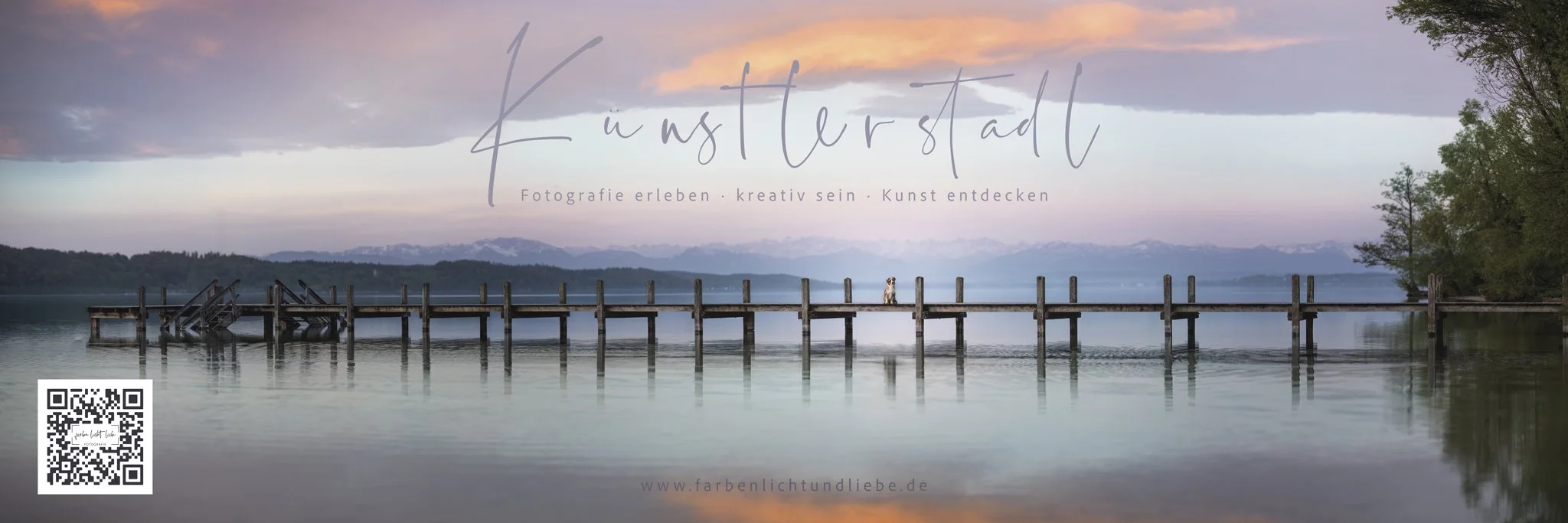 Ein Panorama-Bild eines Sees mit einer alten Holzbrücke, die ins Wasser führt. Es gibt Berge im Hintergrund und einen bewölkten Himmel bei Sonnenaufgang oder Sonnenuntergang.