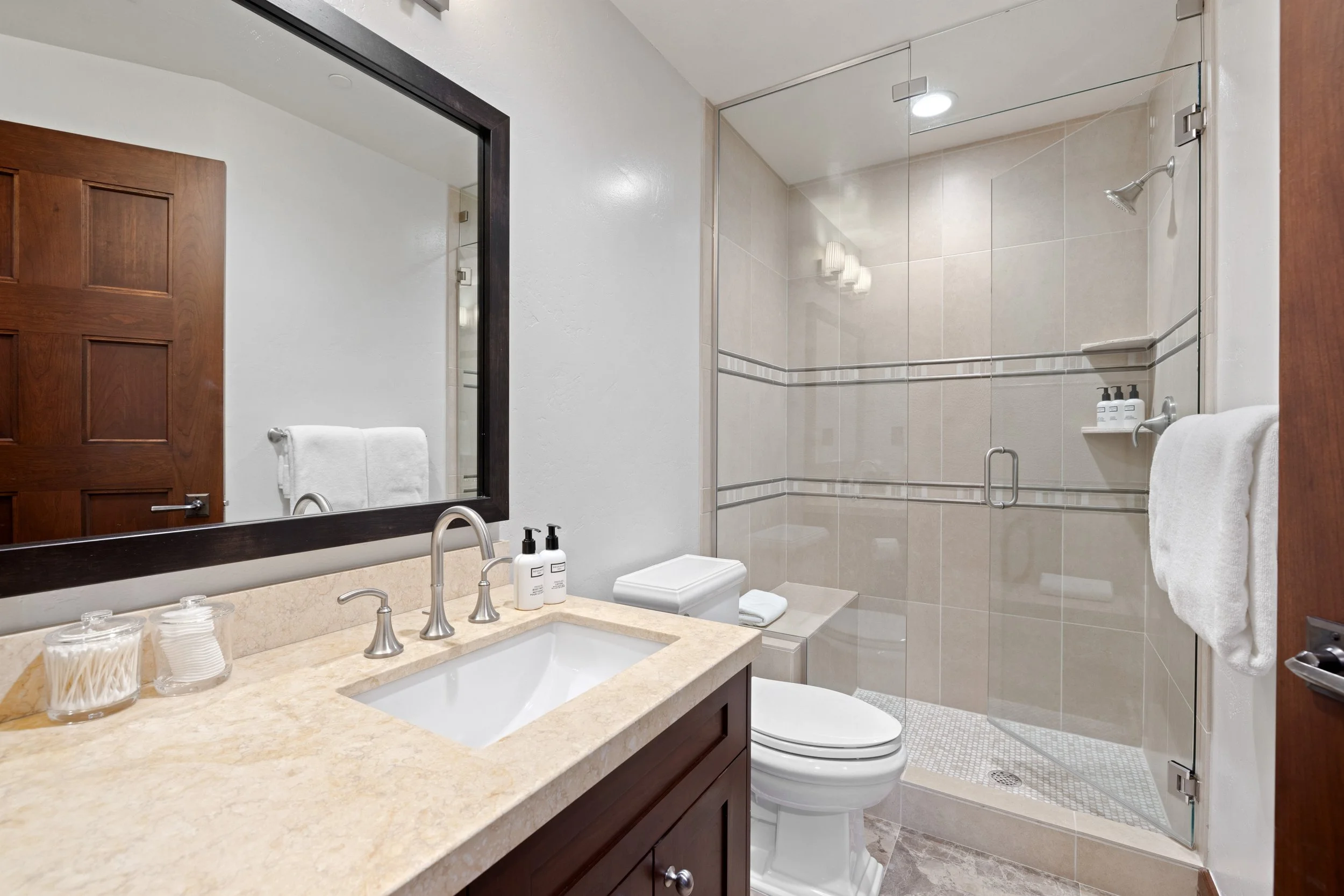 Second bedroom ensuite bath with walk-in glass shower and full amenities