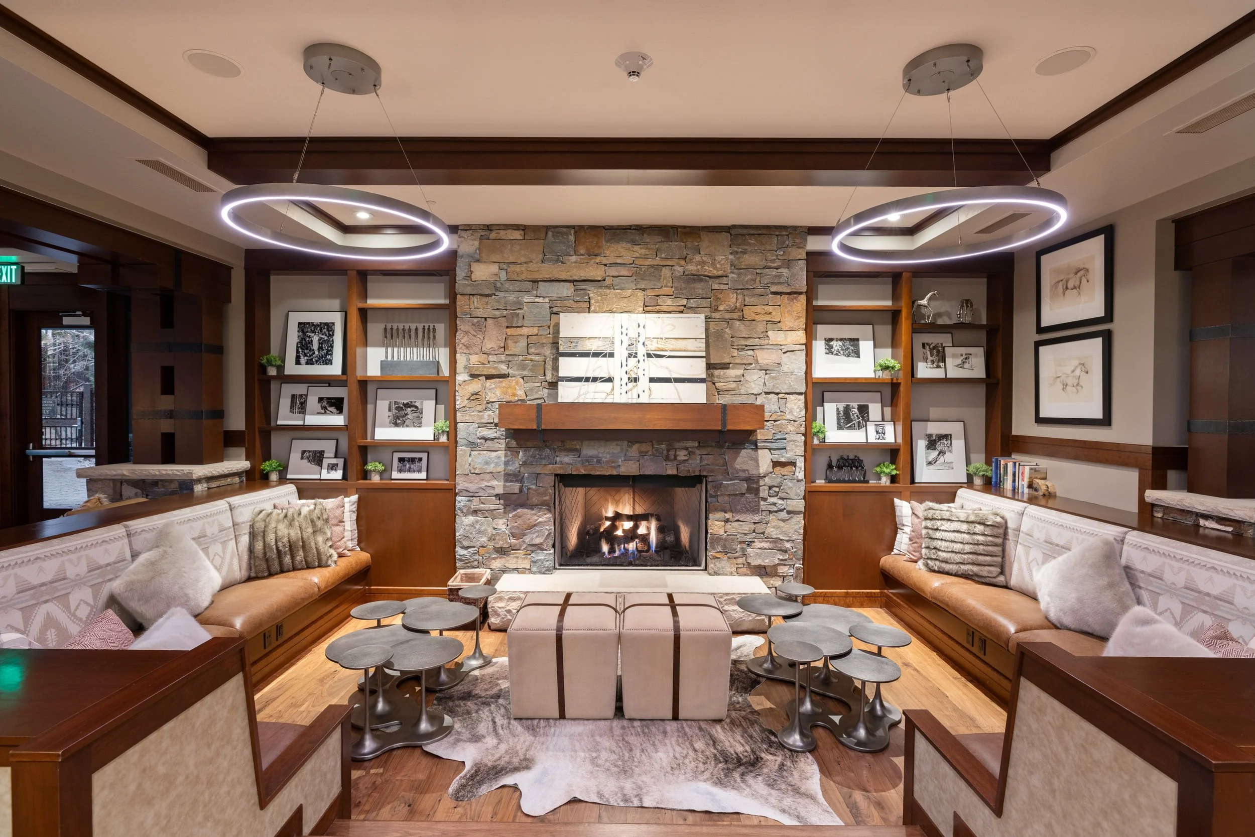 Owners' lounge fireside seating with stone hearth and curated bookshelves