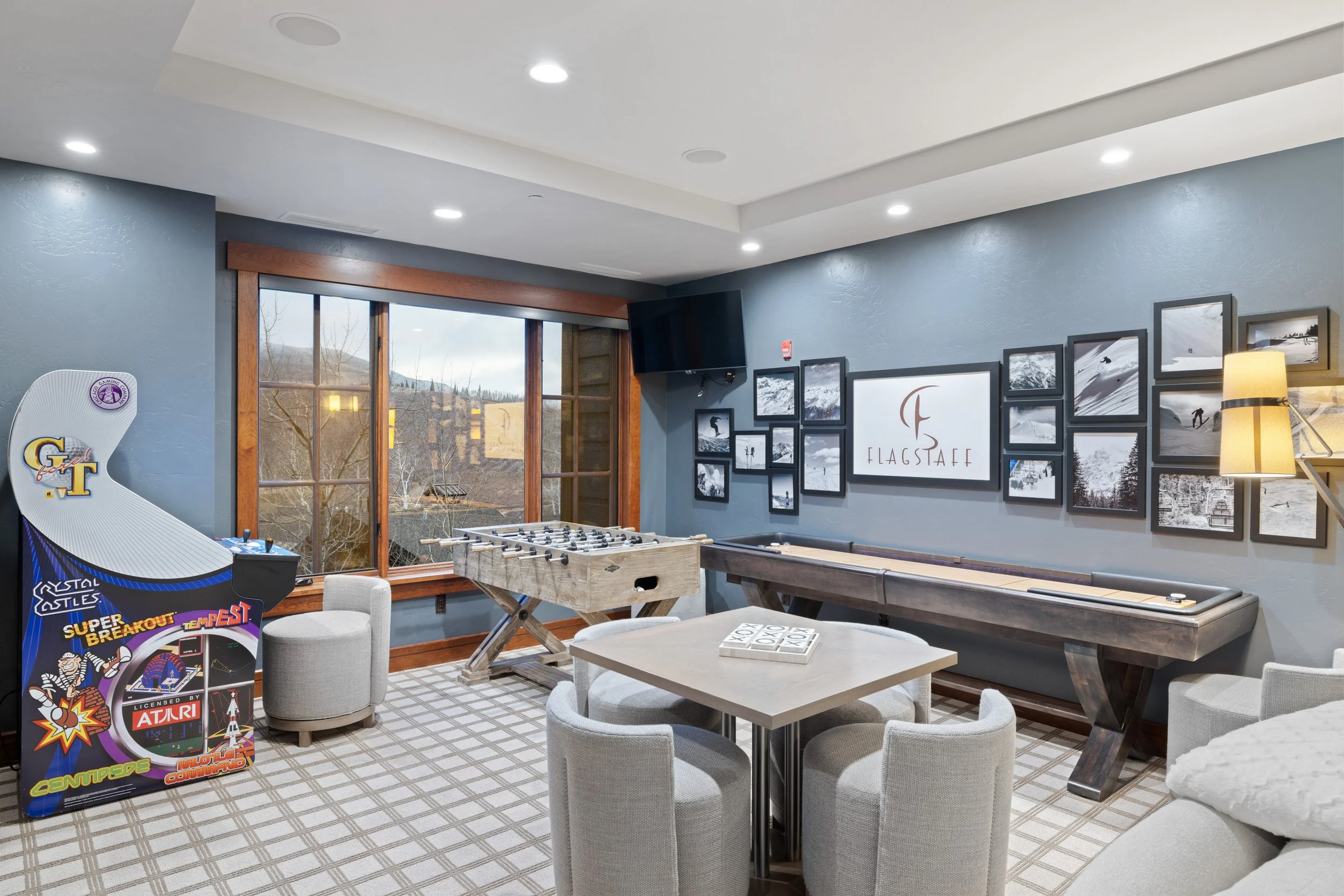 Family game room with arcade games, foosball, shuffleboard, and lounge seating