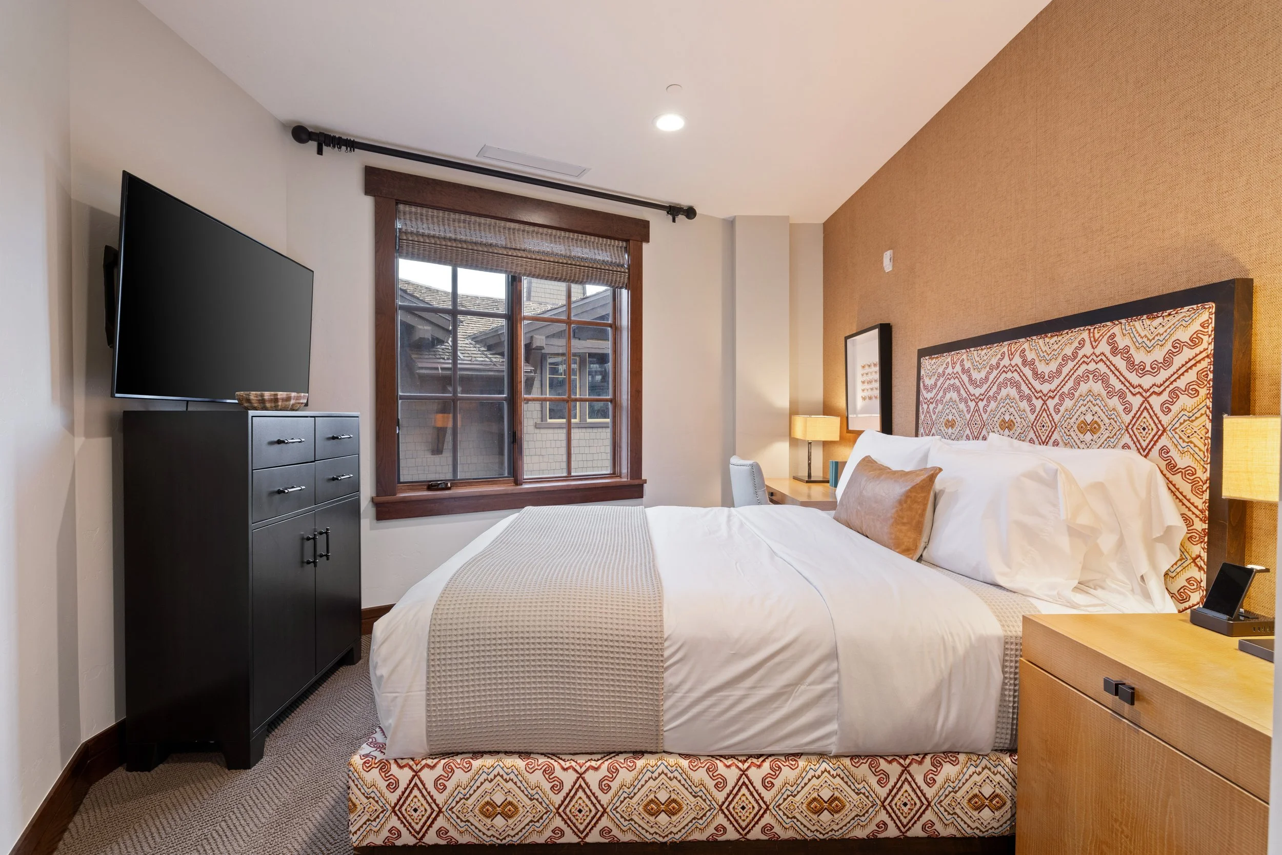 Second bedroom with queen bed, flat-screen TV, and designer linens