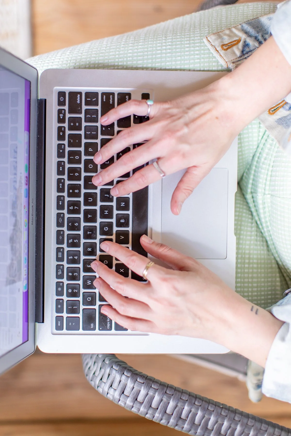 Hands typing on a laptop keyboard, viewed from above.