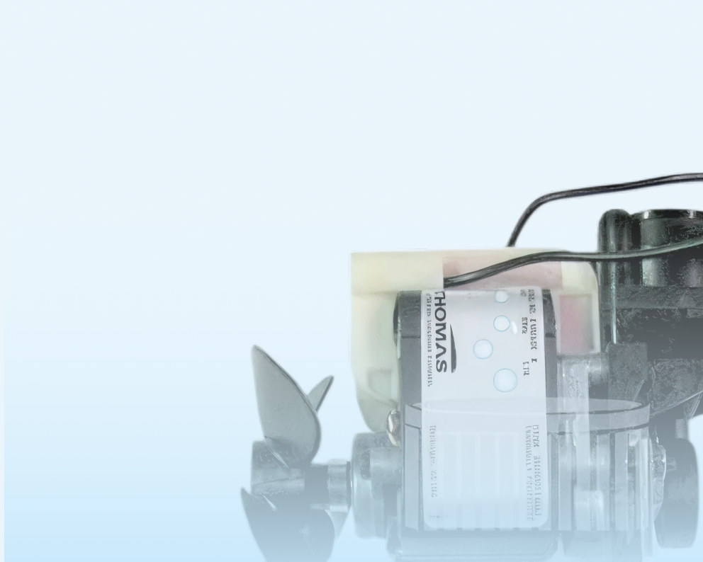 Close-up of a small electric motor with wires attached against a light blue background.