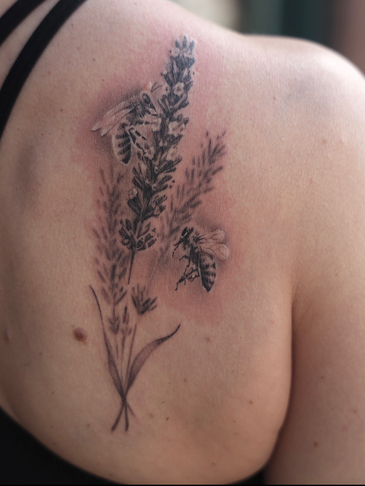 Tattoo of lavender flowers with a bee on a person's shoulder in black and gray realism by the best tattoo artist in Boise, Idaho. 