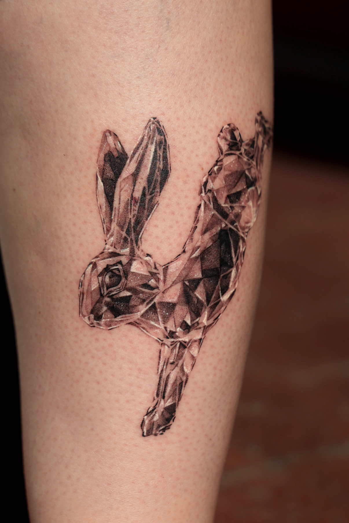 Tattoo of a rabbit designed to look like a diamond made of geometric facets on a person's arm in black and gray realism performed by an award winning tattoo artist in black and gray realism tattooing at Chariot Tattoo in Boise, Idaho. 