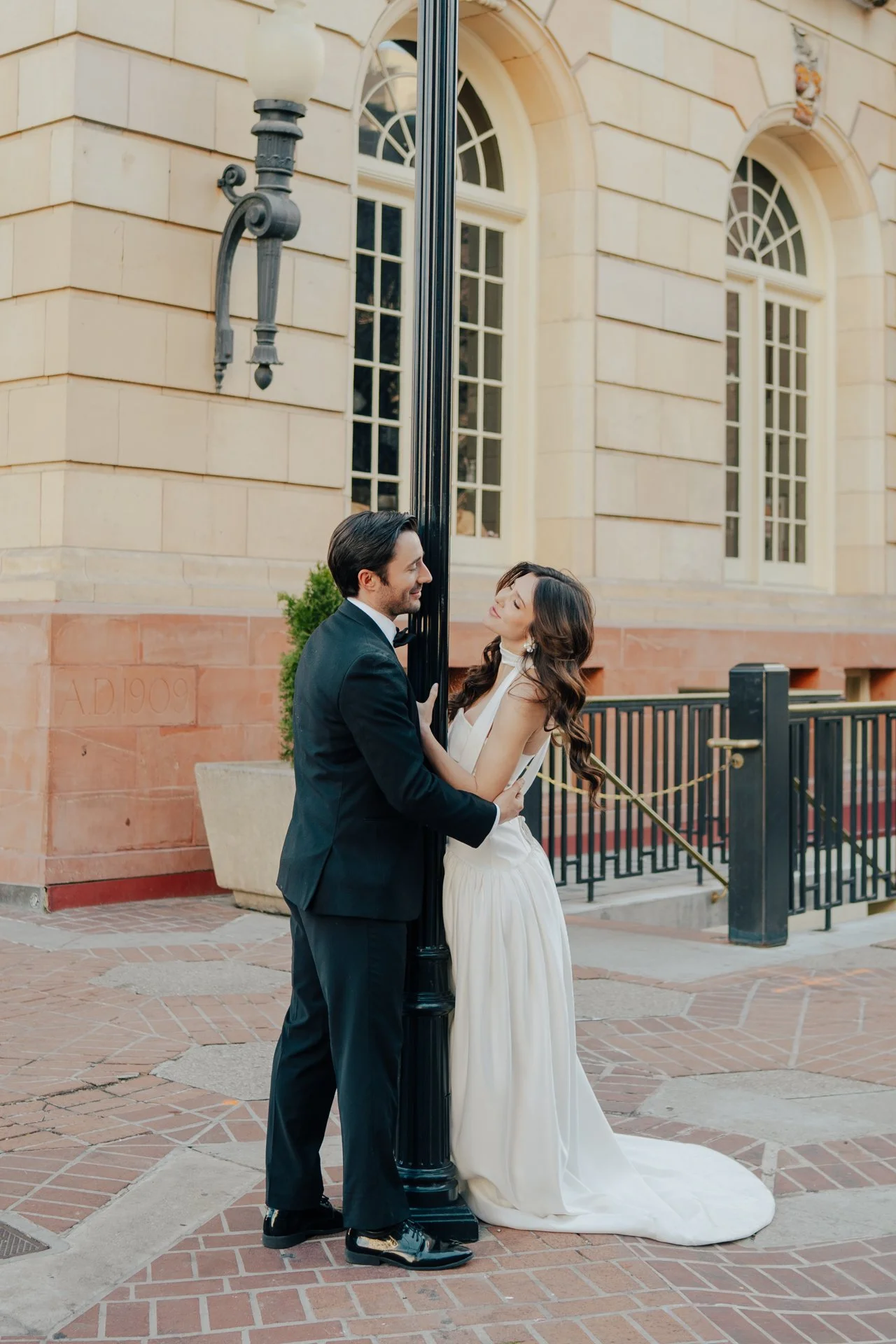 Bride and Groom in classic elegant wedding attire surrounded by beautiful stonework architecture during a downtown formals photoshoot - Poise and Ivy Imagery