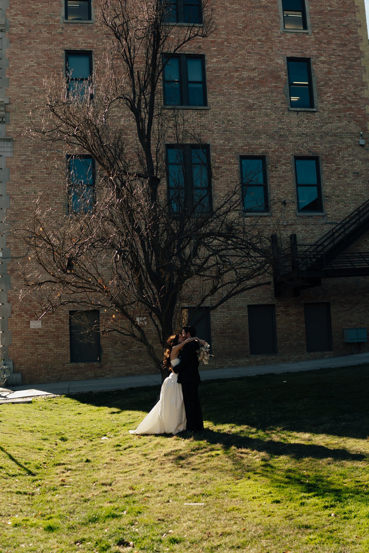 Bride and Groom in classic elegant wedding attire surrounded by beautiful stonework architecture during a downtown formals photoshoot - Poise and Ivy Imagery