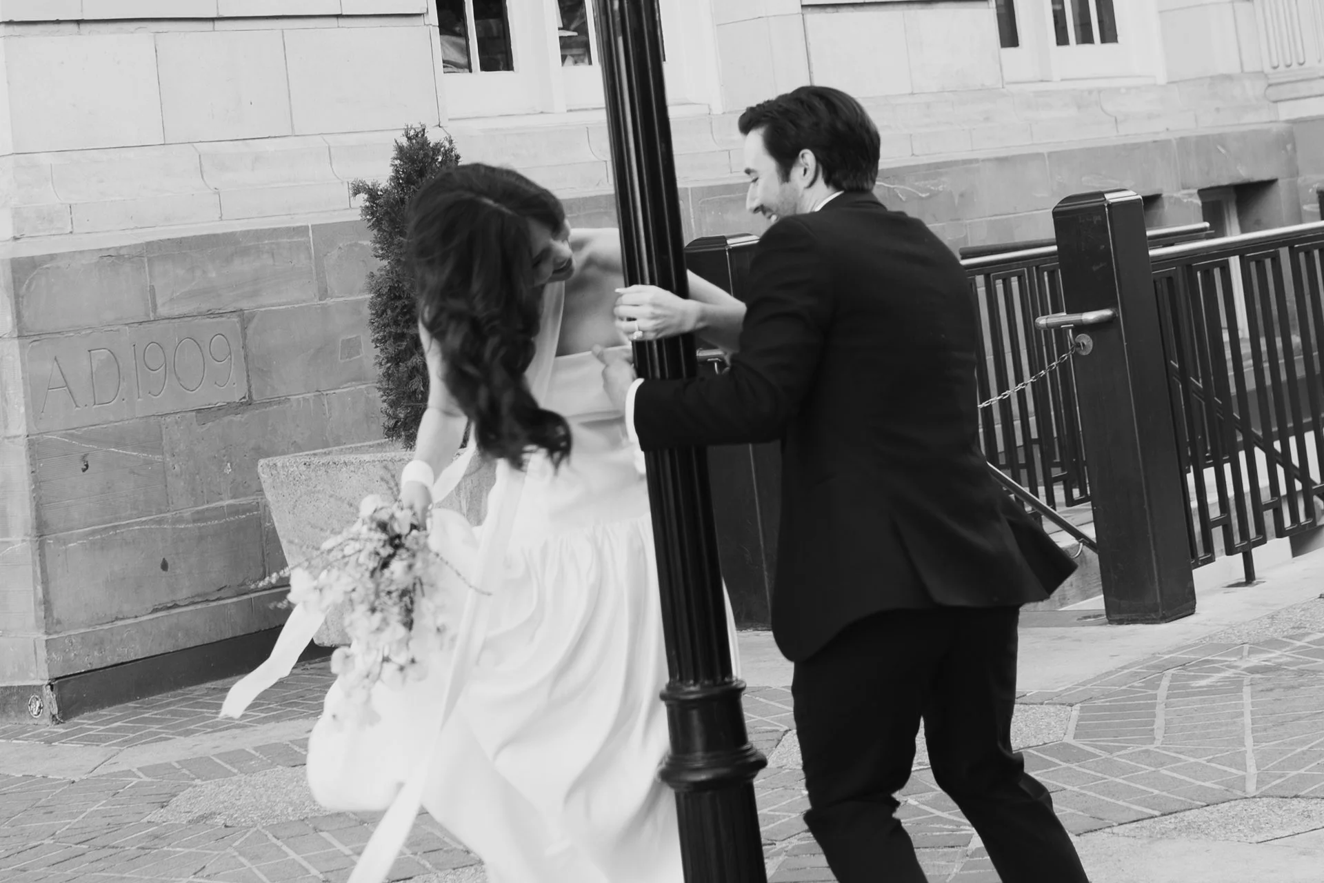 Bride and Groom in classic elegant wedding attire surrounded by beautiful stonework architecture during a downtown formals photoshoot - Poise and Ivy Imagery
