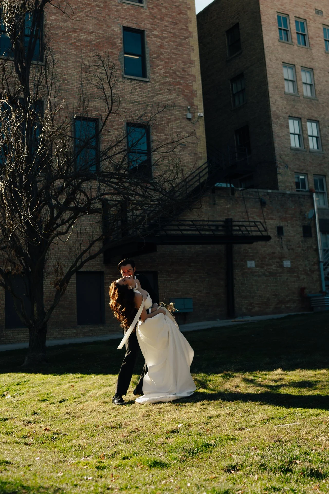 Bride and Groom in classic elegant wedding attire surrounded by beautiful stonework architecture during a downtown formals photoshoot - Poise and Ivy Imagery