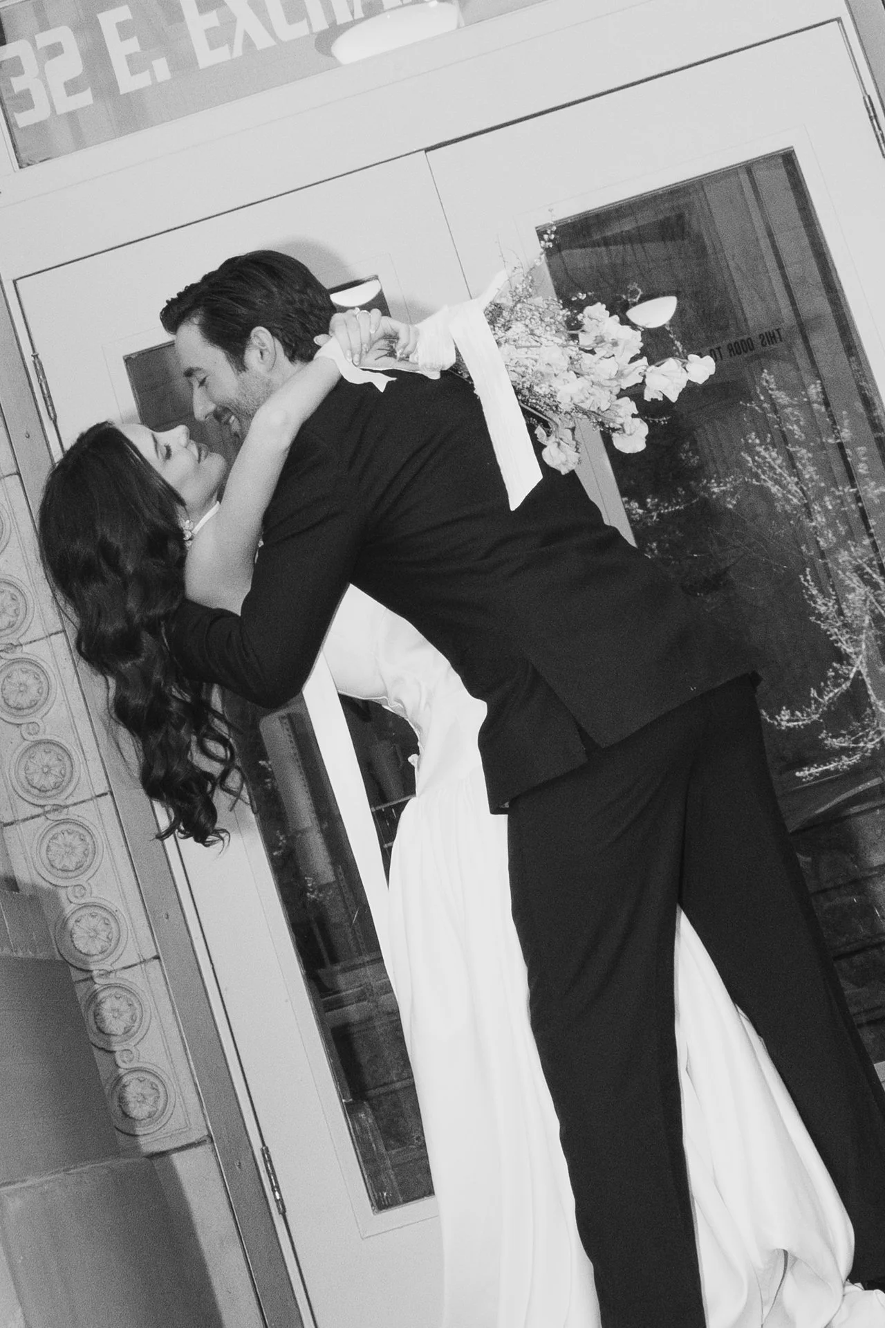 Bride and Groom in classic elegant wedding attire surrounded by beautiful stonework architecture during a downtown formals photoshoot - Poise and Ivy Imagery