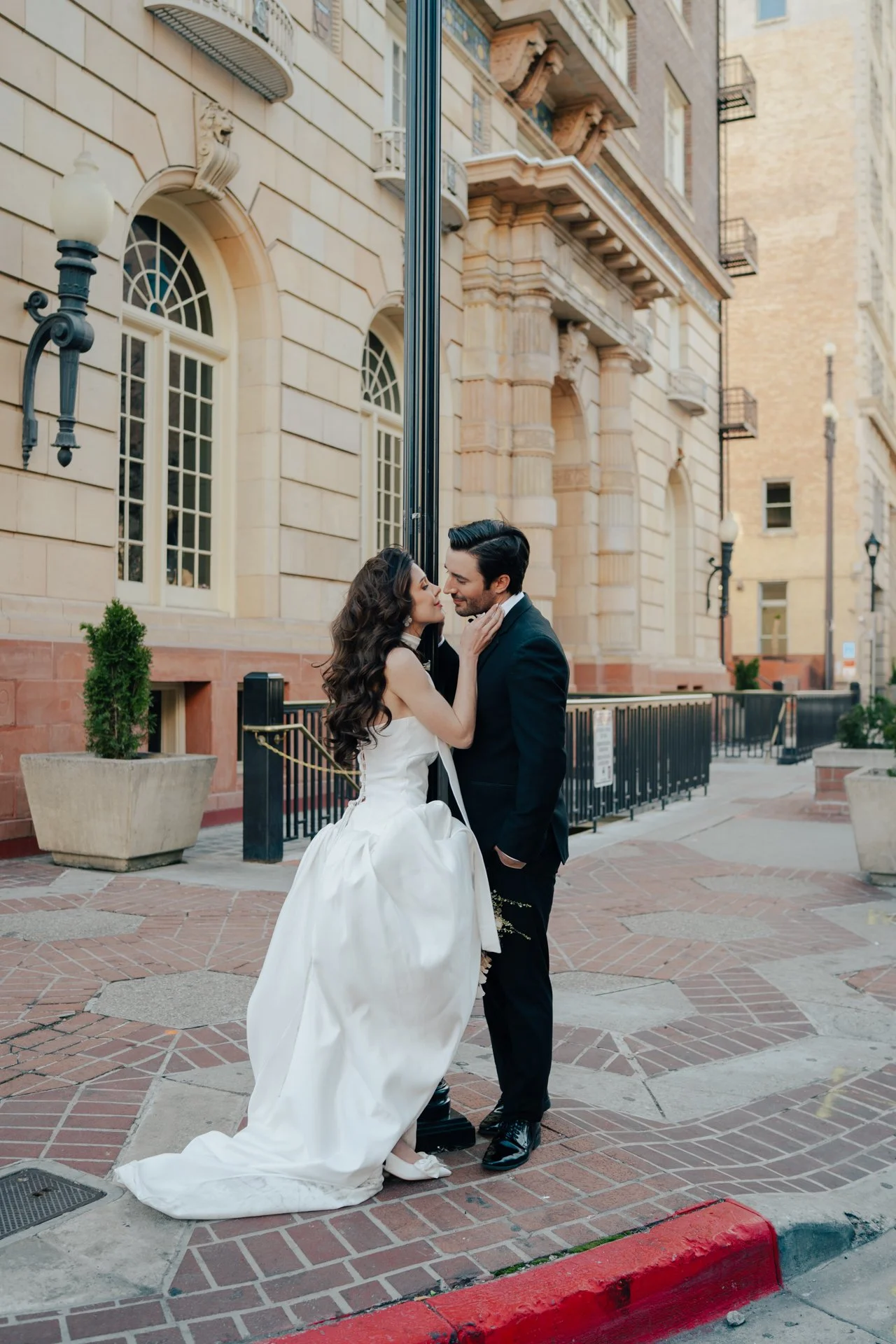 Bride and Groom in classic elegant wedding attire surrounded by beautiful stonework architecture during a downtown formals photoshoot - Poise and Ivy Imagery