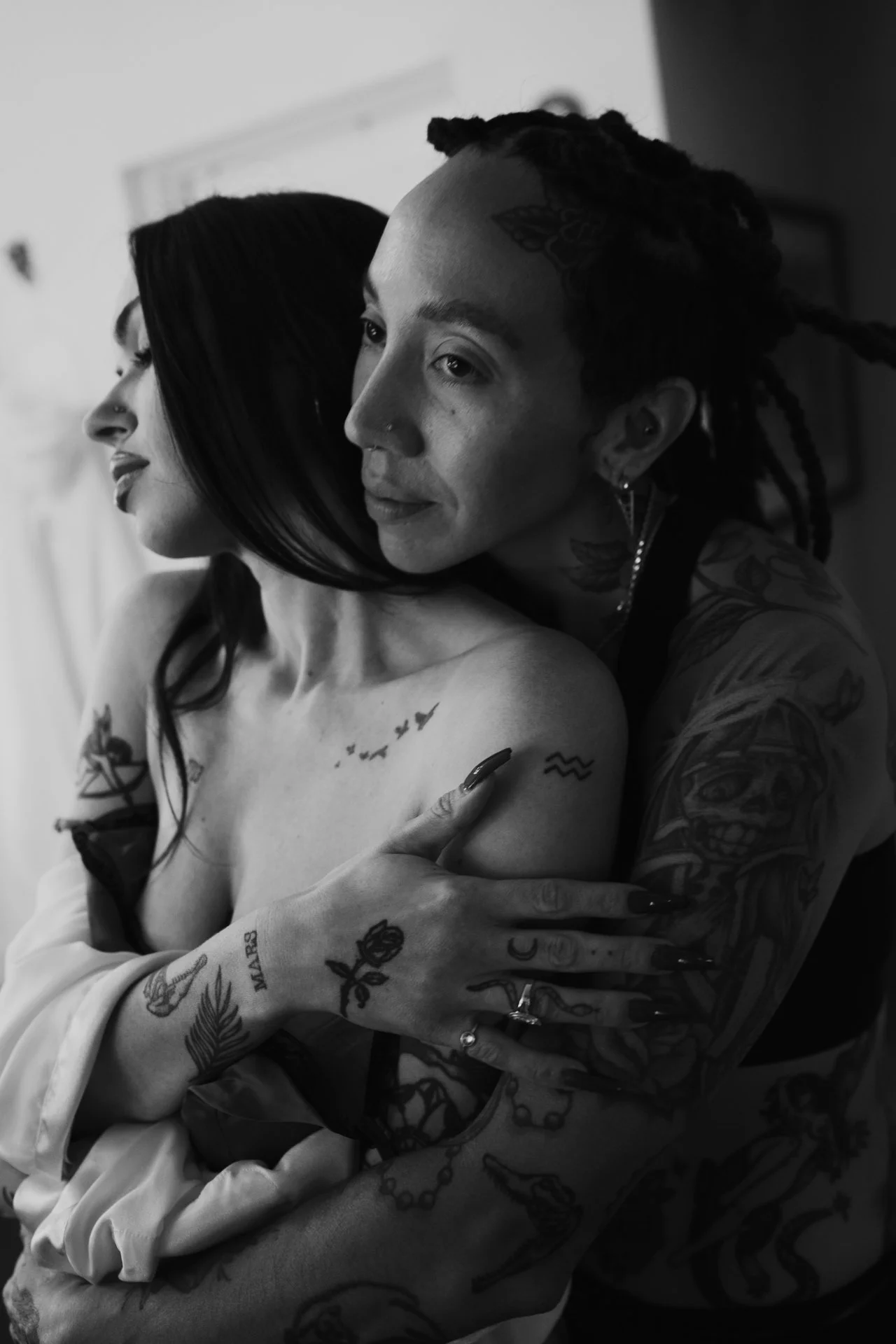 a tattooed couple embrace each other as they dress in their wedding attire - photographed by Poise and Ivy Imagery