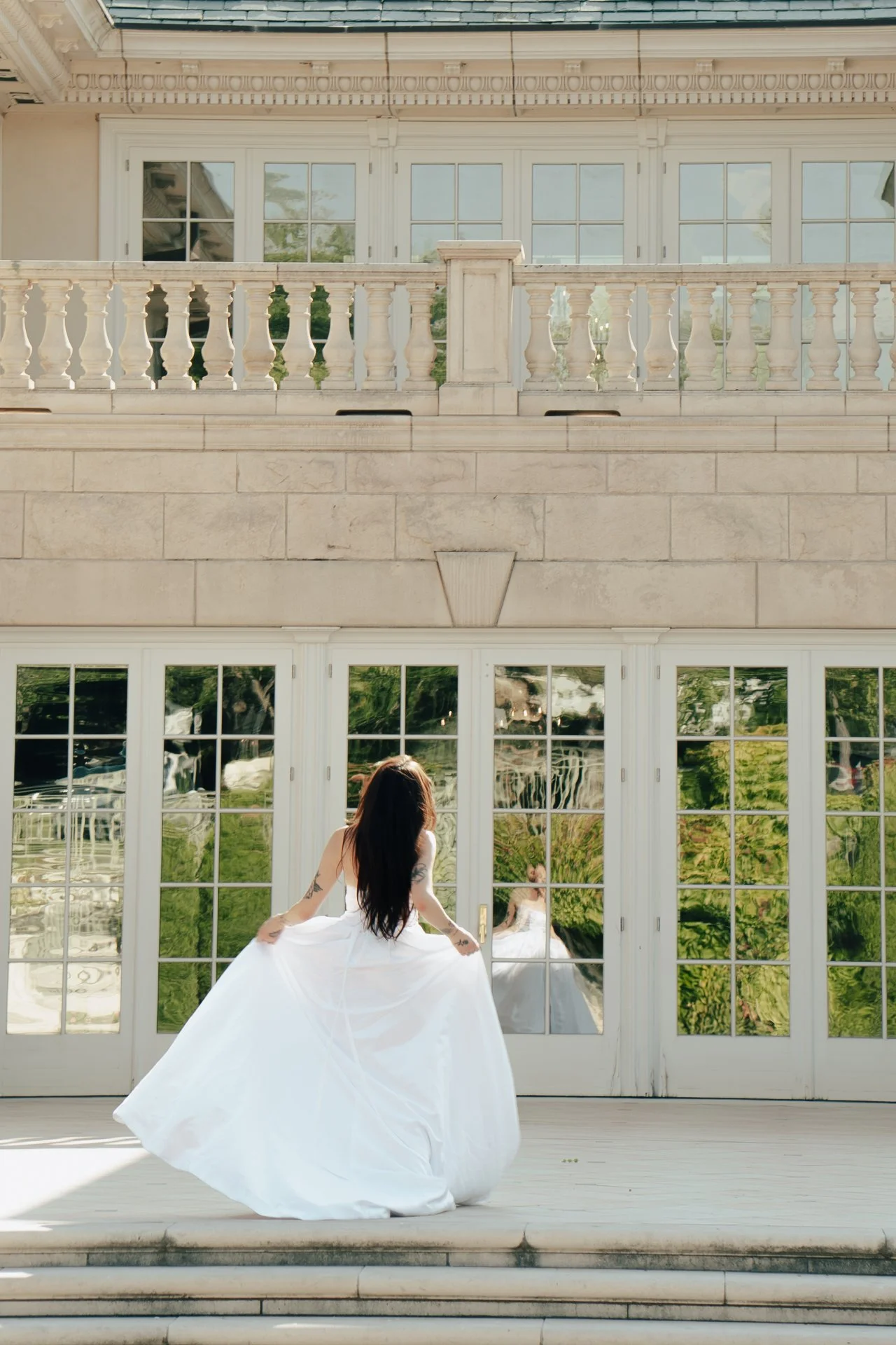 a bride spins in her wedding dress in an ornate foyer - photographed by Poise and Ivy Imagery