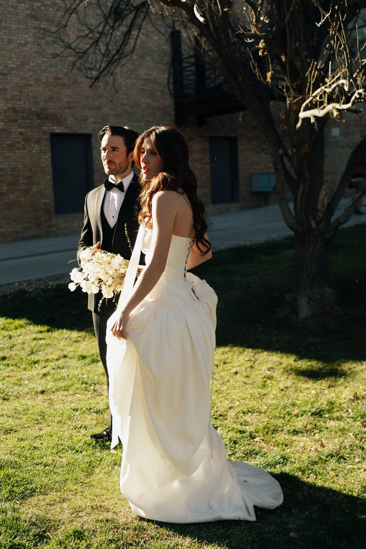 Bride and Groom in classic elegant wedding attire in a sunlit garden during a downtown formals photoshoot - Poise and Ivy Imagery