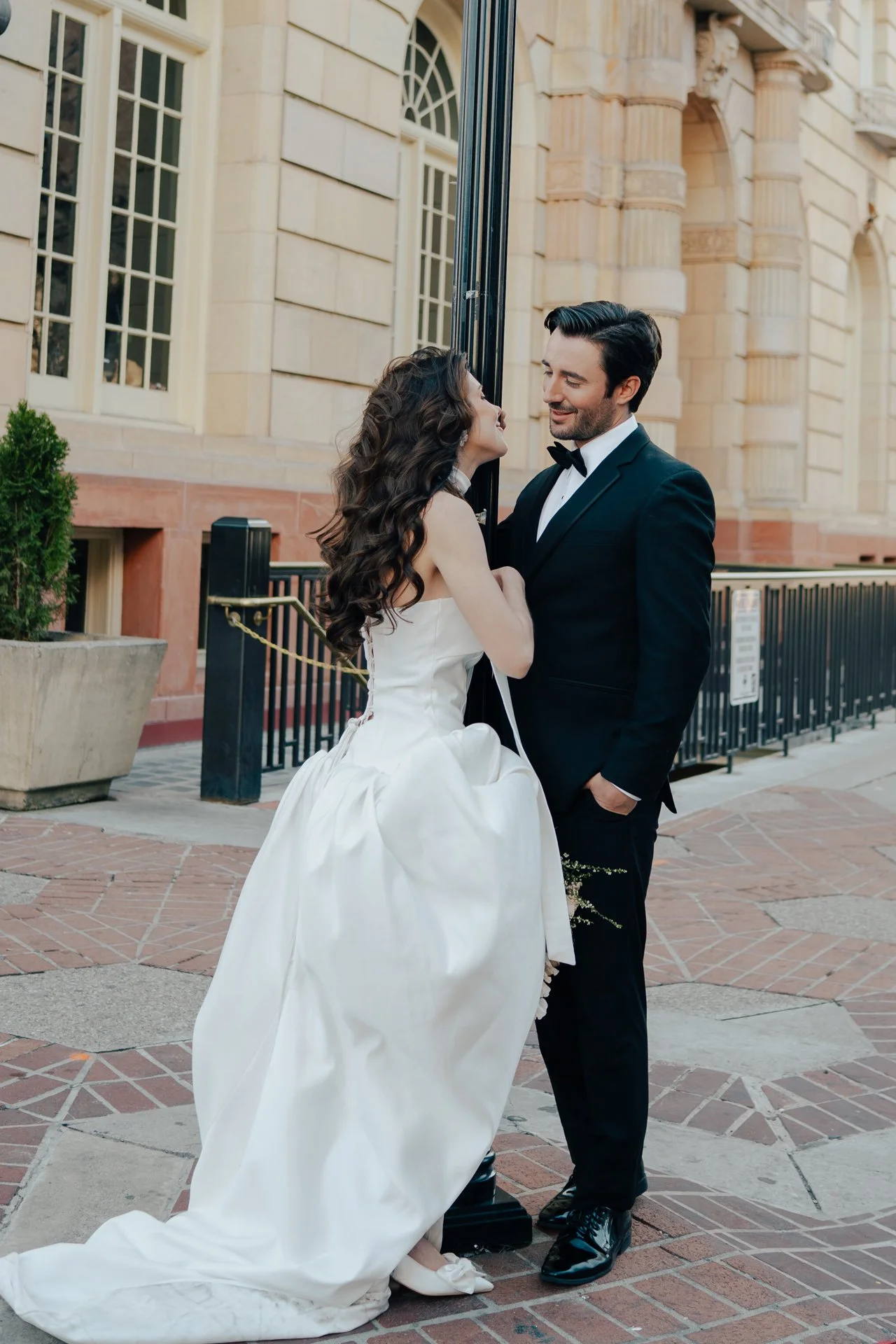 Bride and Groom in classic elegant wedding attire surrounded by beautiful stonework architecture during a downtown formals photoshoot - Poise and Ivy Imagery