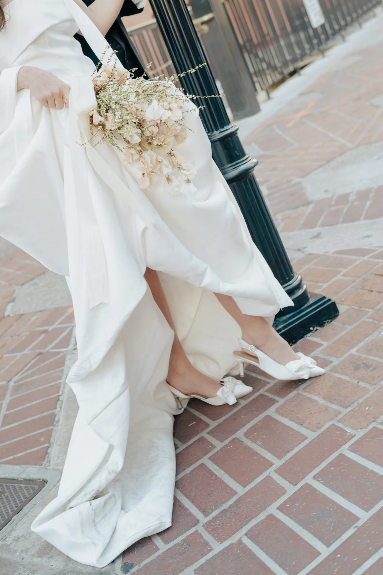 Bride and Groom in classic elegant wedding attire surrounded by beautiful stonework architecture during a downtown formals photoshoot - Poise and Ivy Imagery