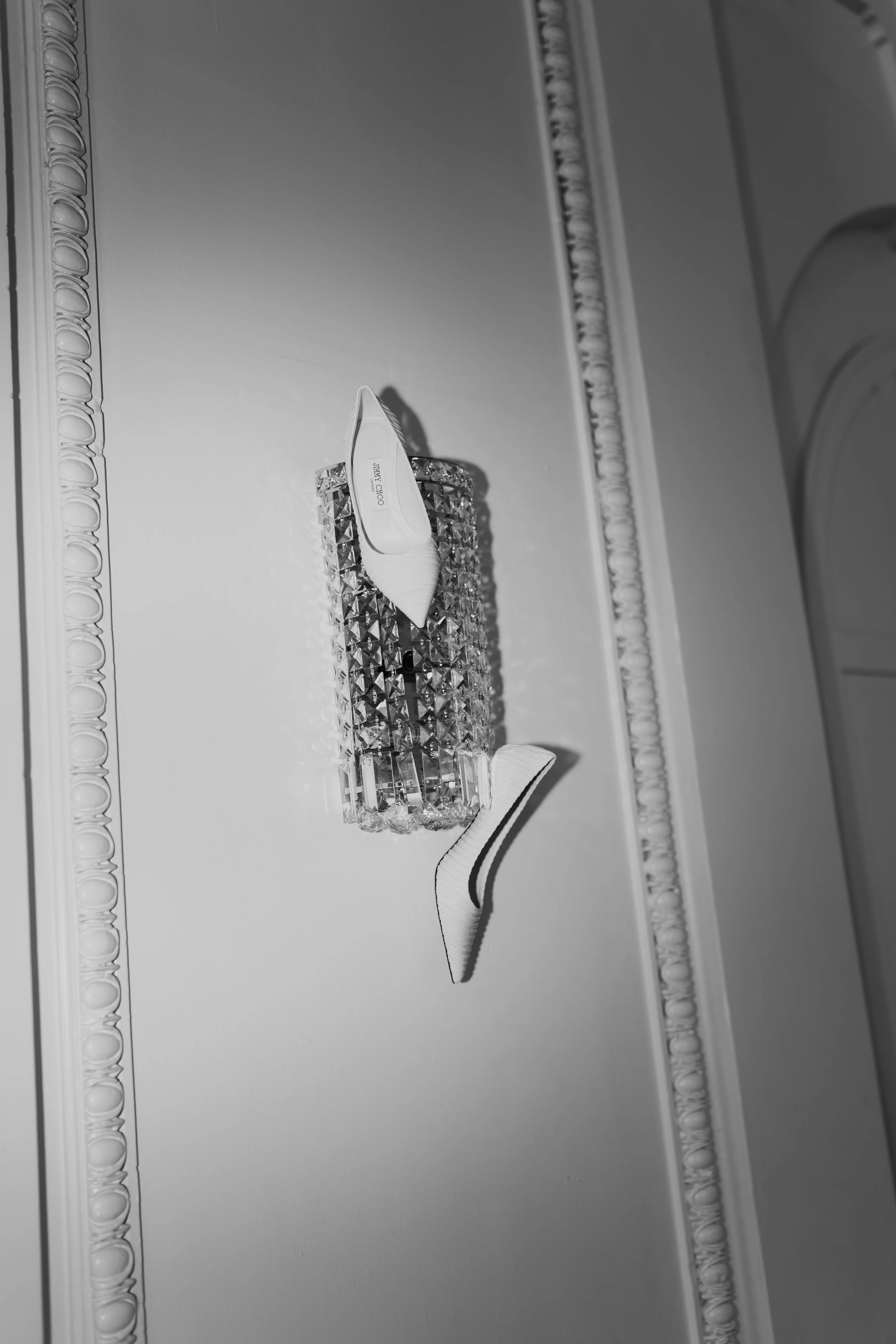 Bride's wedding heels hang from a crystal chandelier , photography by Poise & Ivy Imagery