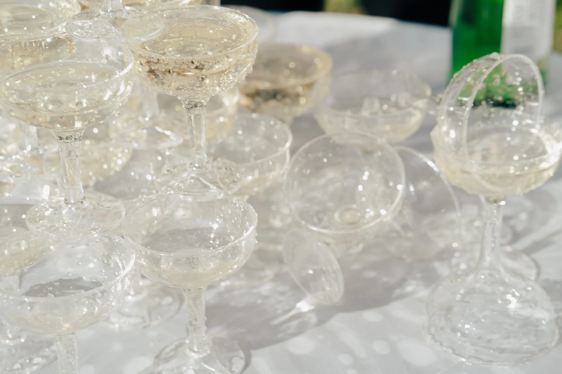 a tower of champagne glasses after a celebratory champagne pour at a wedding - poise and ivy imagery