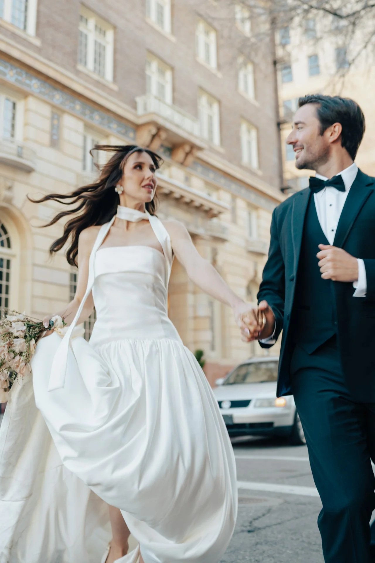 Bride and Groom in classic elegant wedding attire surrounded by beautiful stonework architecture during a downtown formals photoshoot - Poise and Ivy Imagery