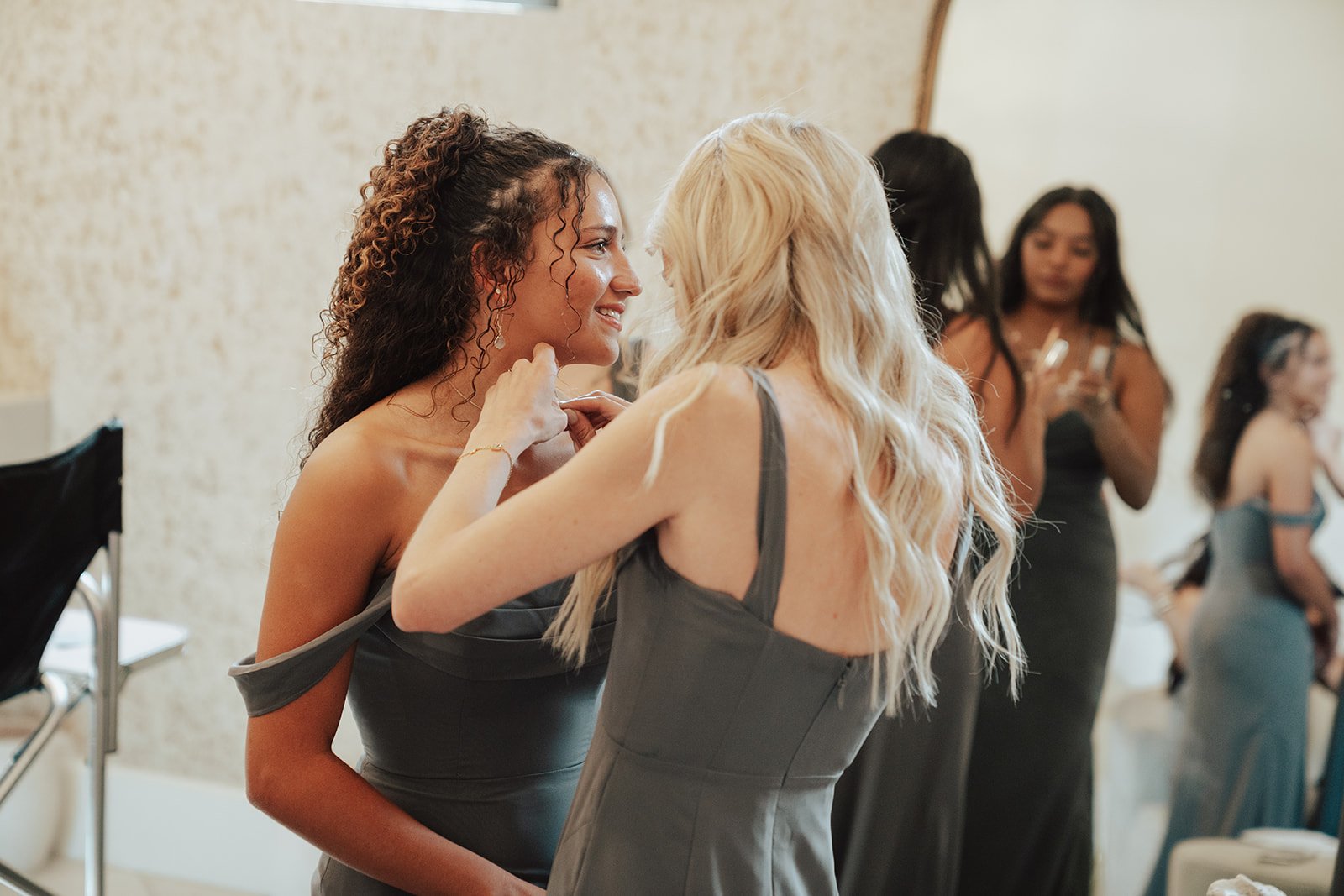 bridesmaids in grey dresses getting ready together before the wedding ceremony - photography by poise and ivy imagery