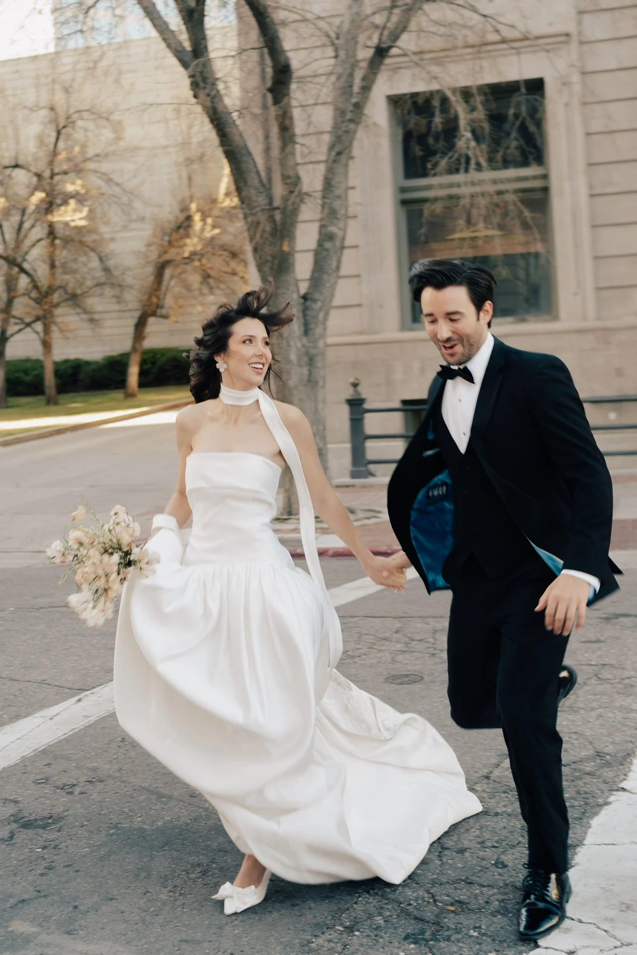 Bride and Groom in classic elegant wedding attire surrounded by beautiful stonework architecture during a downtown formals photoshoot - Poise and Ivy Imagery