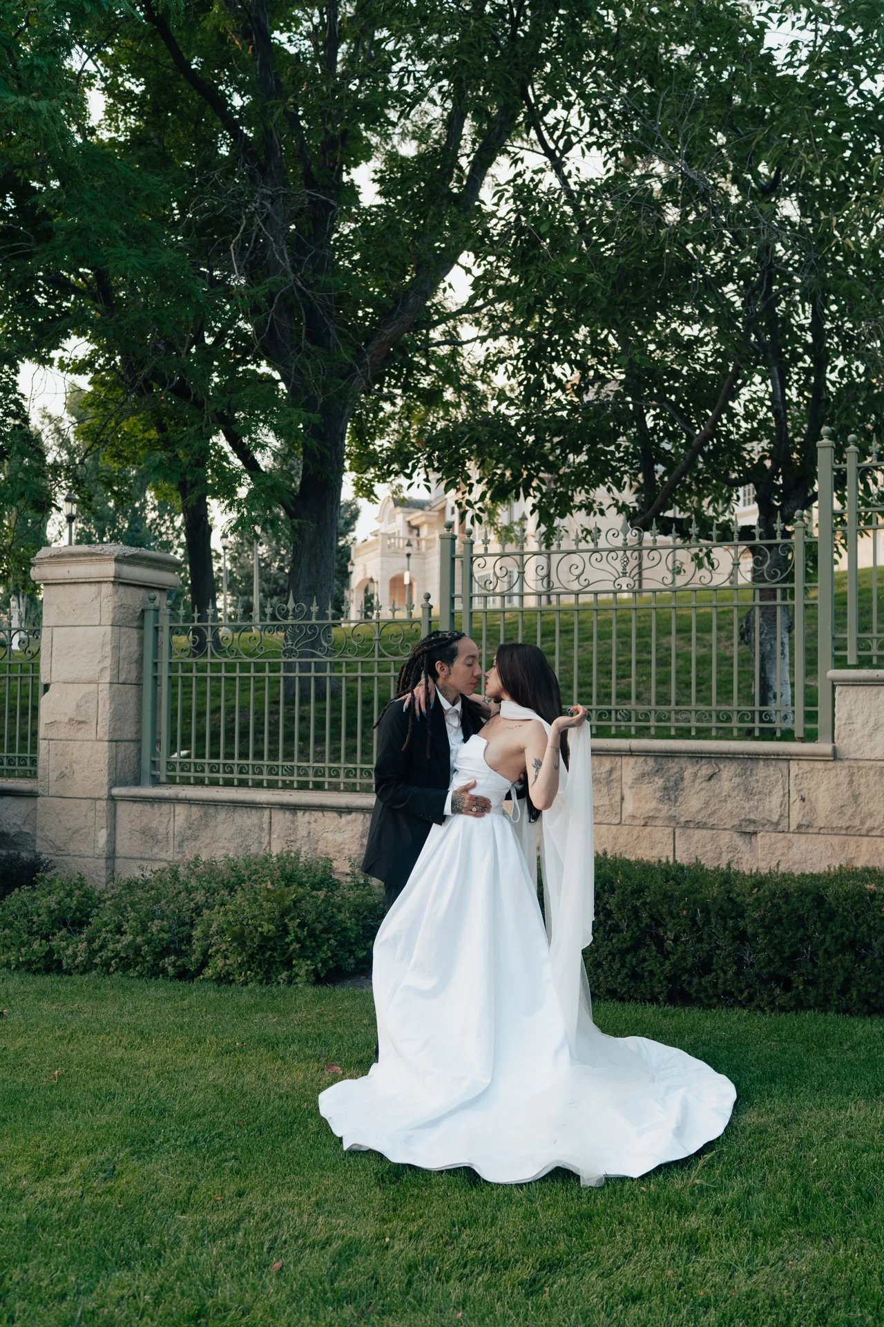Two brides embrace in front of an ornamental museum of art - poise and ivy imagery