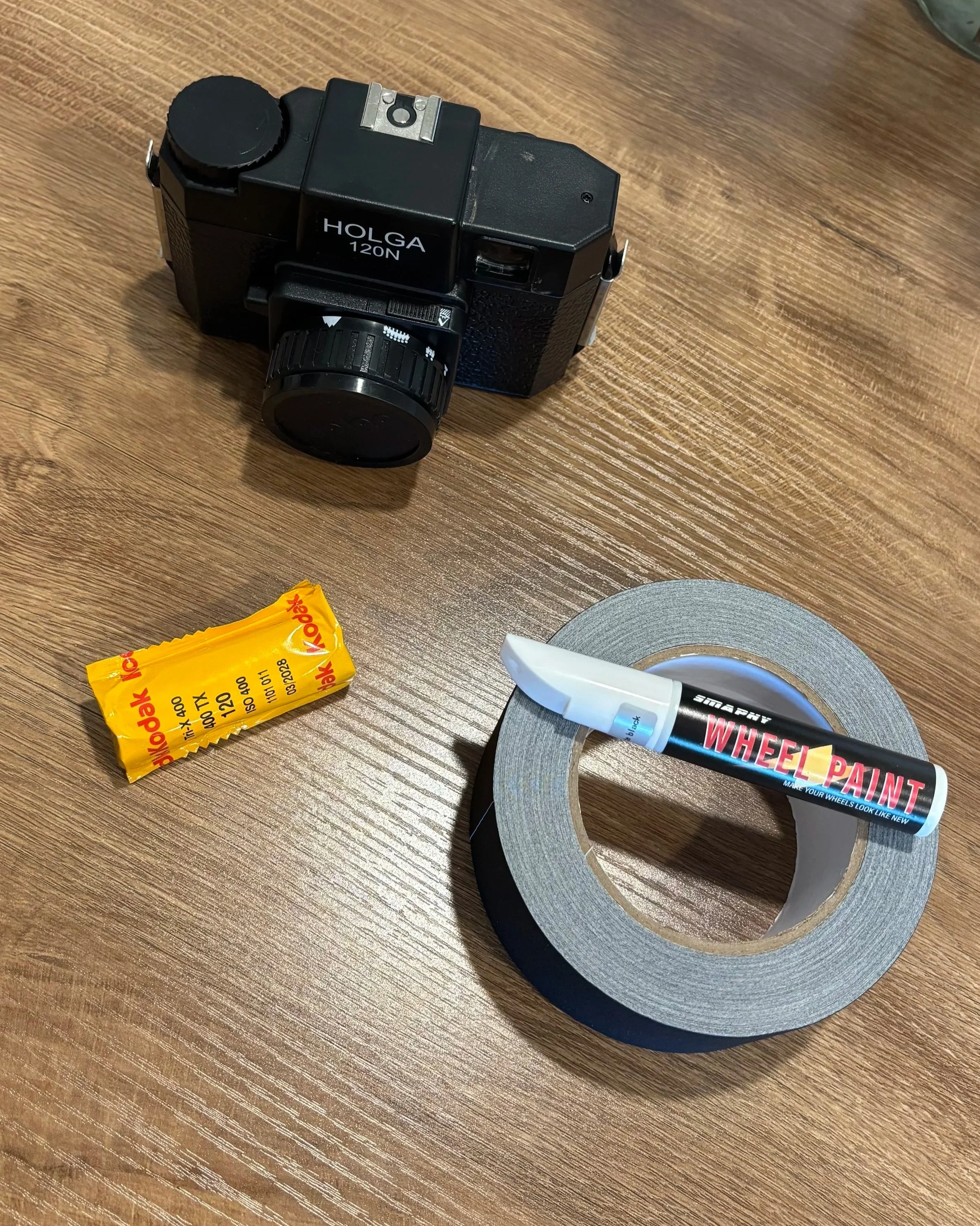 film, gaffer tape, matte paint, and a holga 120 n camera ready to be prepped for a photoshoot