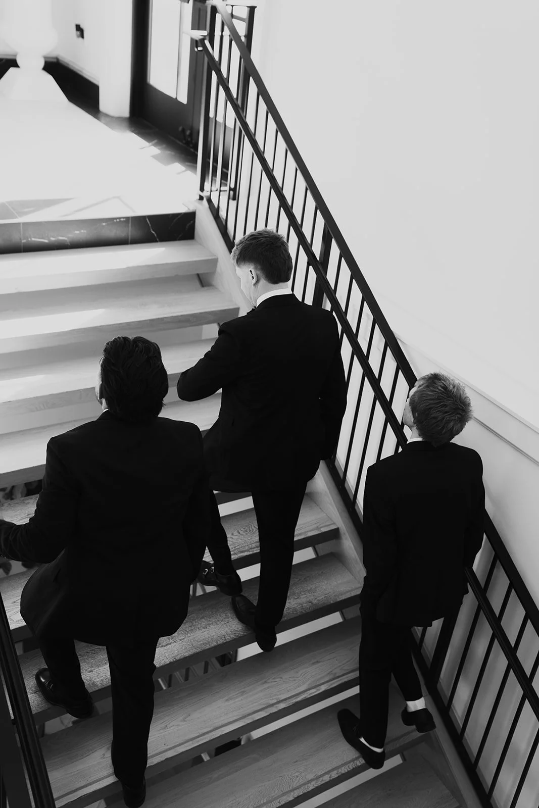 groom and groomsmen walking up a set of stairs preparing for the wedding ceremony - photography by Poise and Ivy Imagery