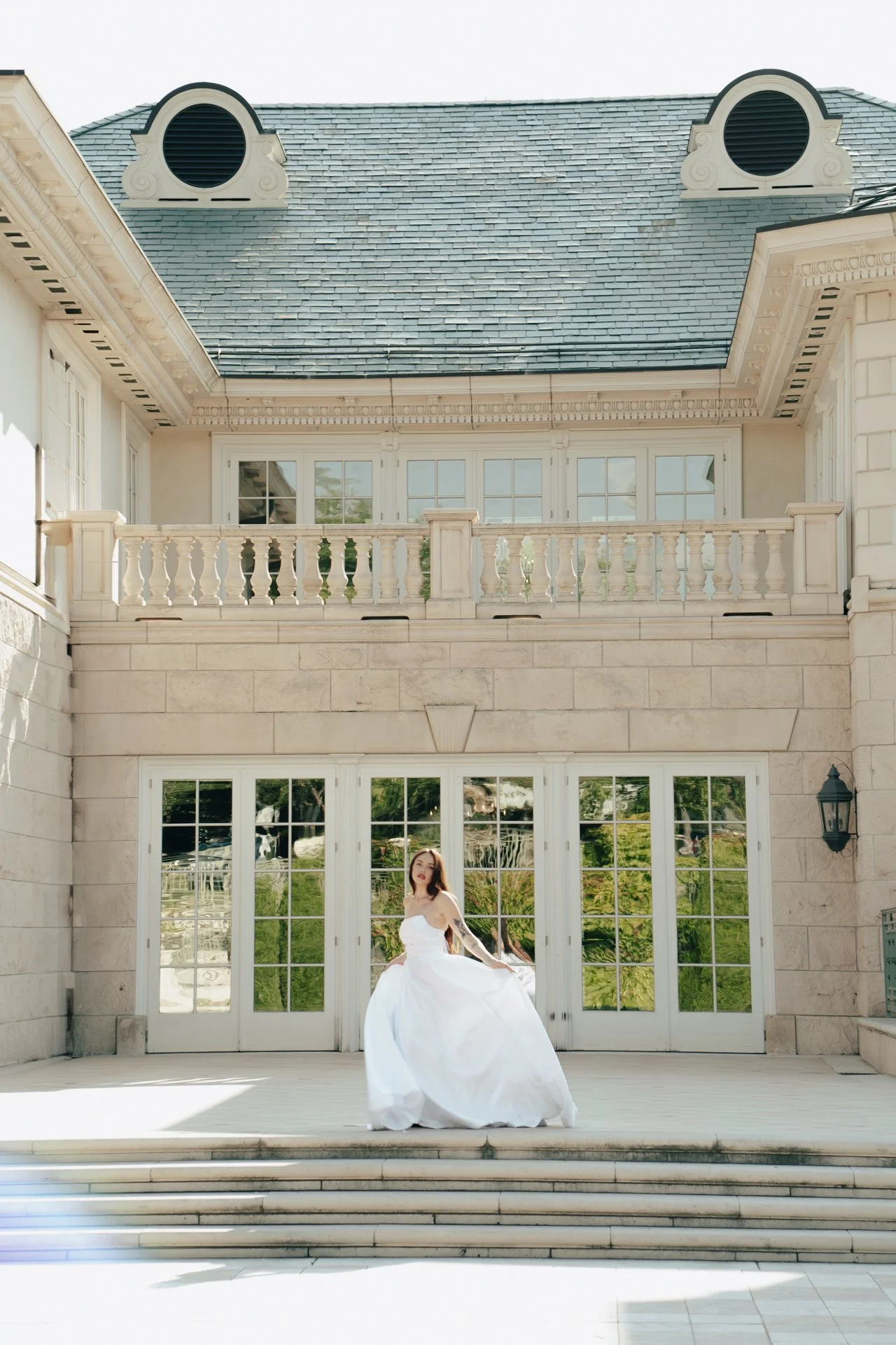a bride spins in her wedding dress in an ornate foyer - photographed by Poise and Ivy Imagery