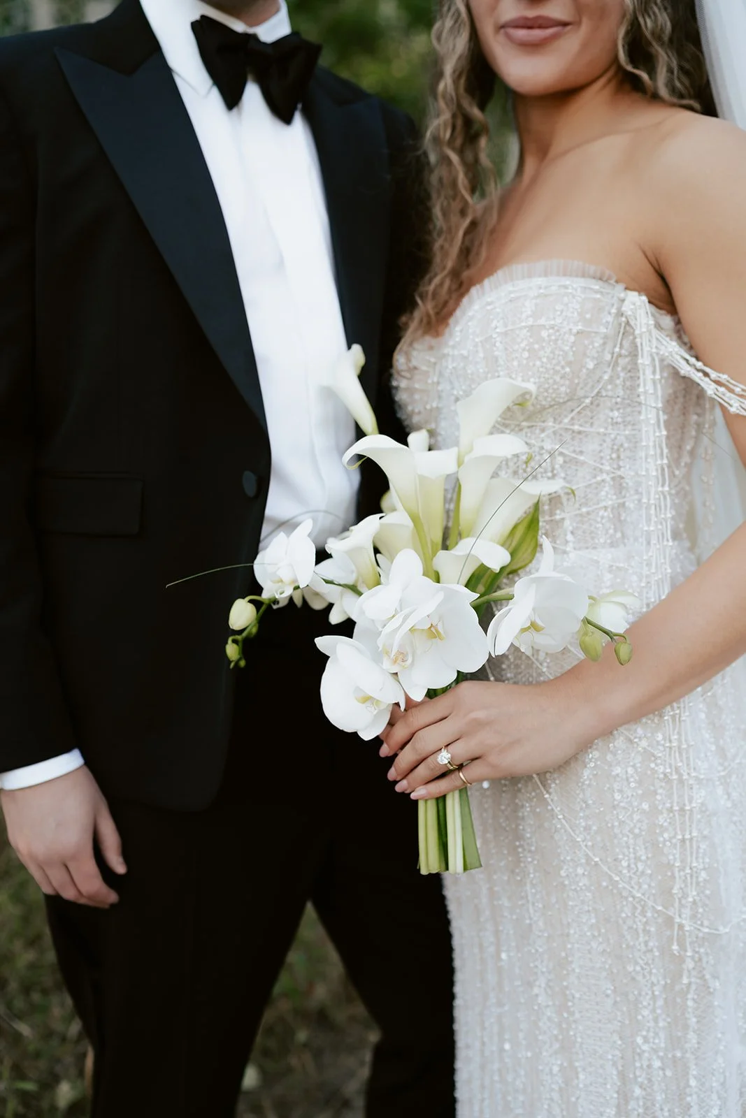 a bride and a groom stand together in a lush aspen grove. the bride wears a beaded wedding gown with a bridal veil and the groom wears a tuxedo. Photography by Poise and Ivy Imagery