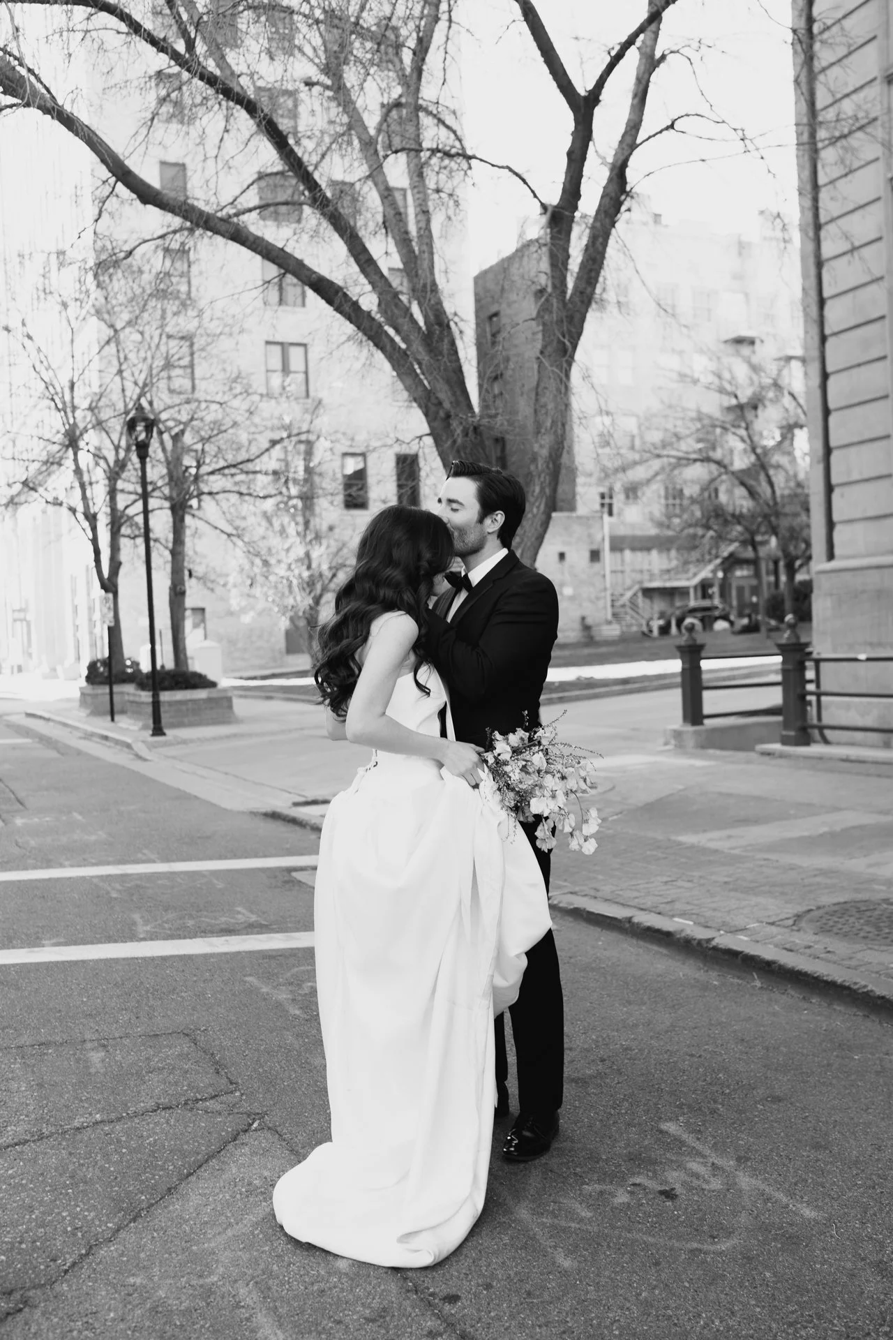 Bride and Groom in classic elegant wedding attire surrounded by beautiful stonework architecture during a downtown formals photoshoot - Poise and Ivy Imagery