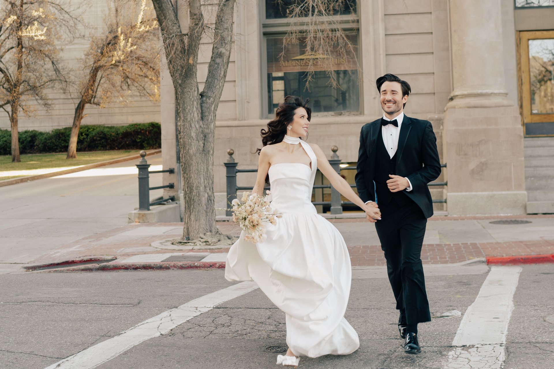 Bride and Groom in classic elegant wedding attire surrounded by beautiful stonework architecture during a downtown formals photoshoot - Poise and Ivy Imagery