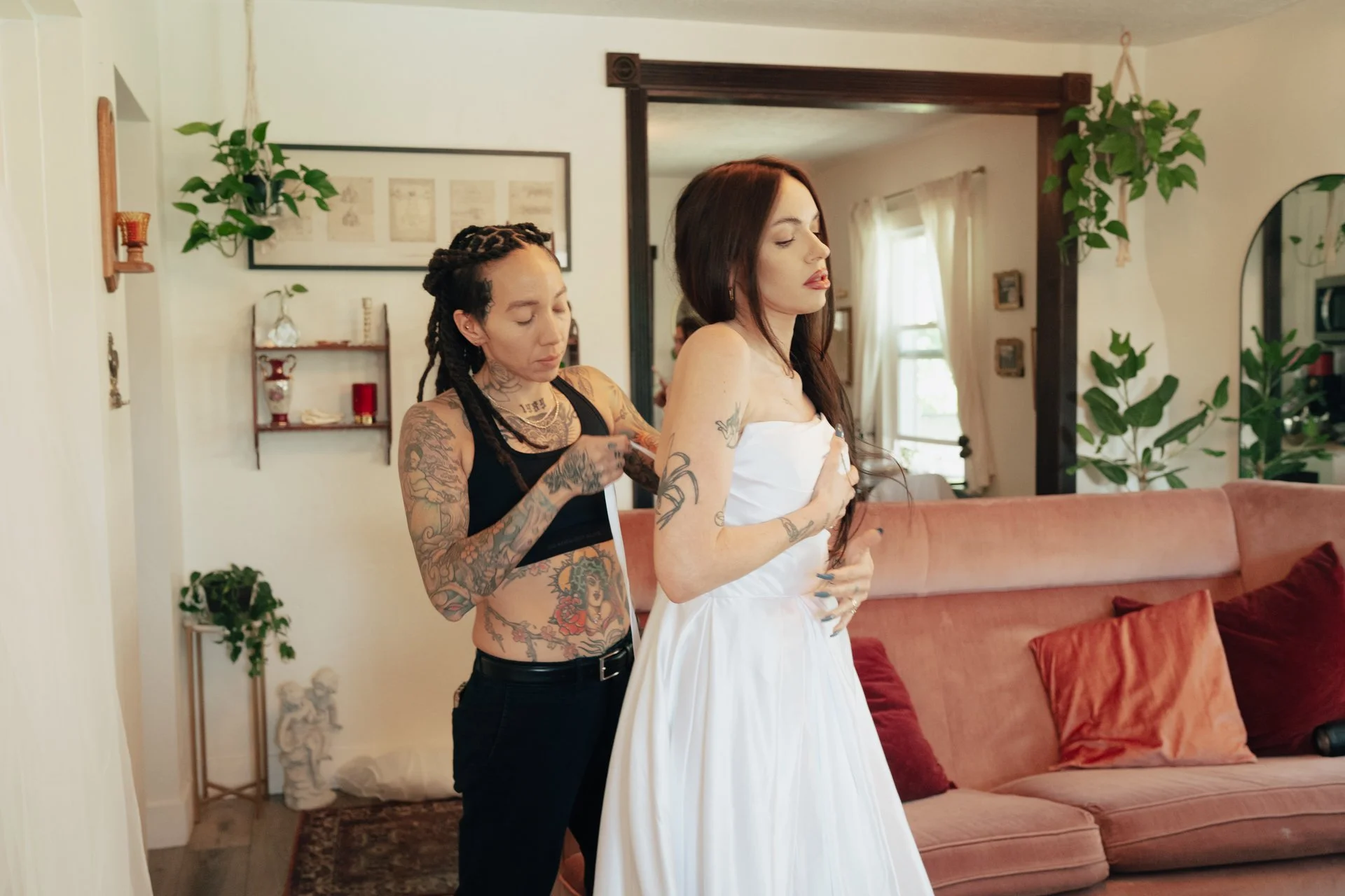 a tattooed couple embrace each other as they dress in their wedding attire - photographed by Poise and Ivy Imagery